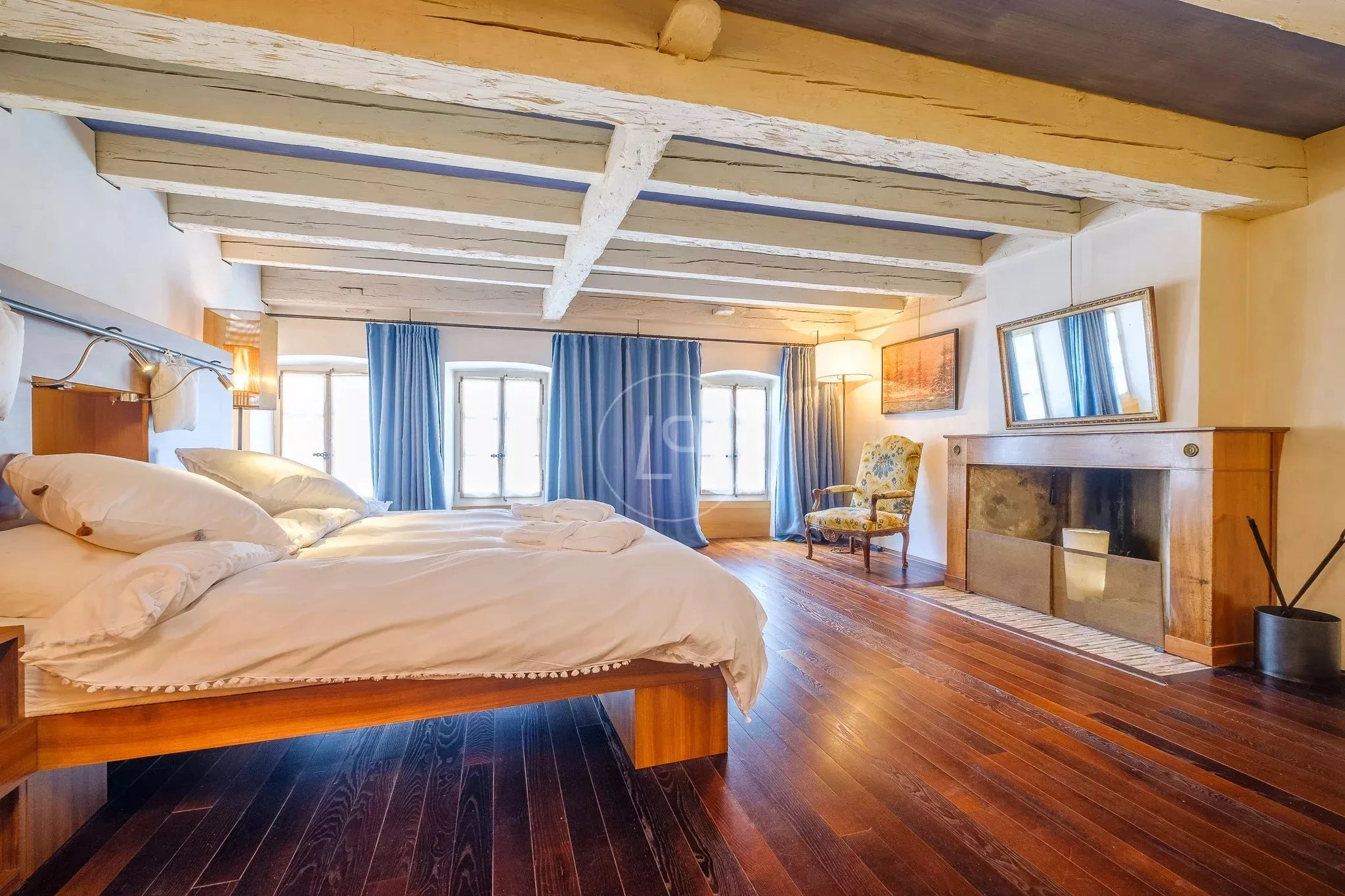 Schlafzimmer mit Kamin und sichtbaren Holzbalken