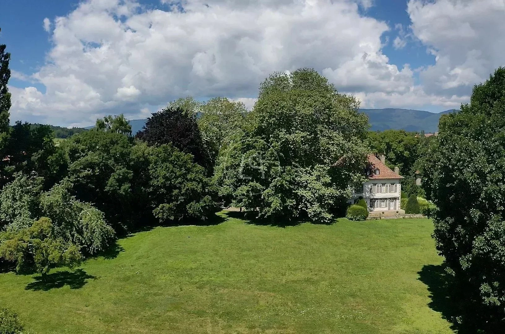 Landschaft mit Herrenhaus und Park
