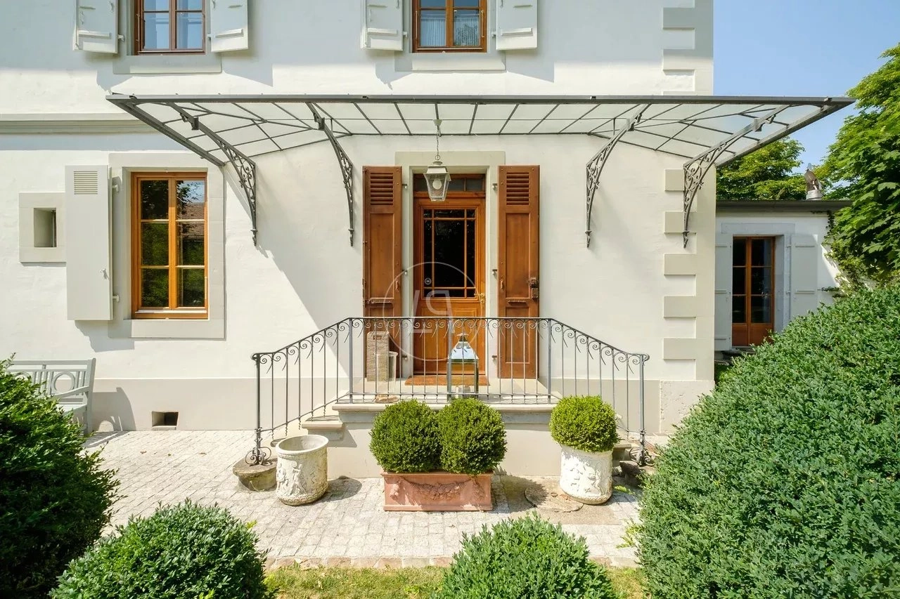 Weiße Hausfassade mit Hauseingang und Vorgarten