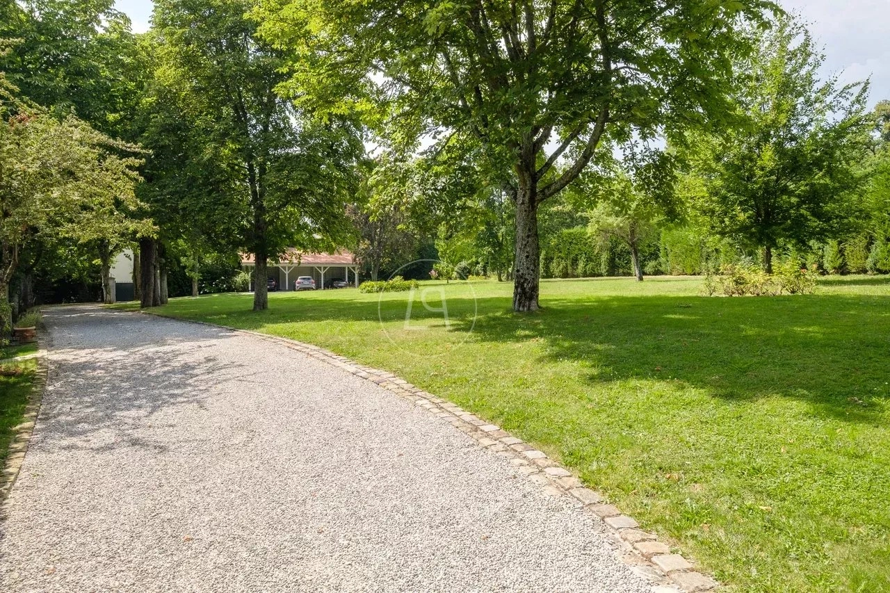 Parkähnliche Zufahrt mit Garten und Bäumen