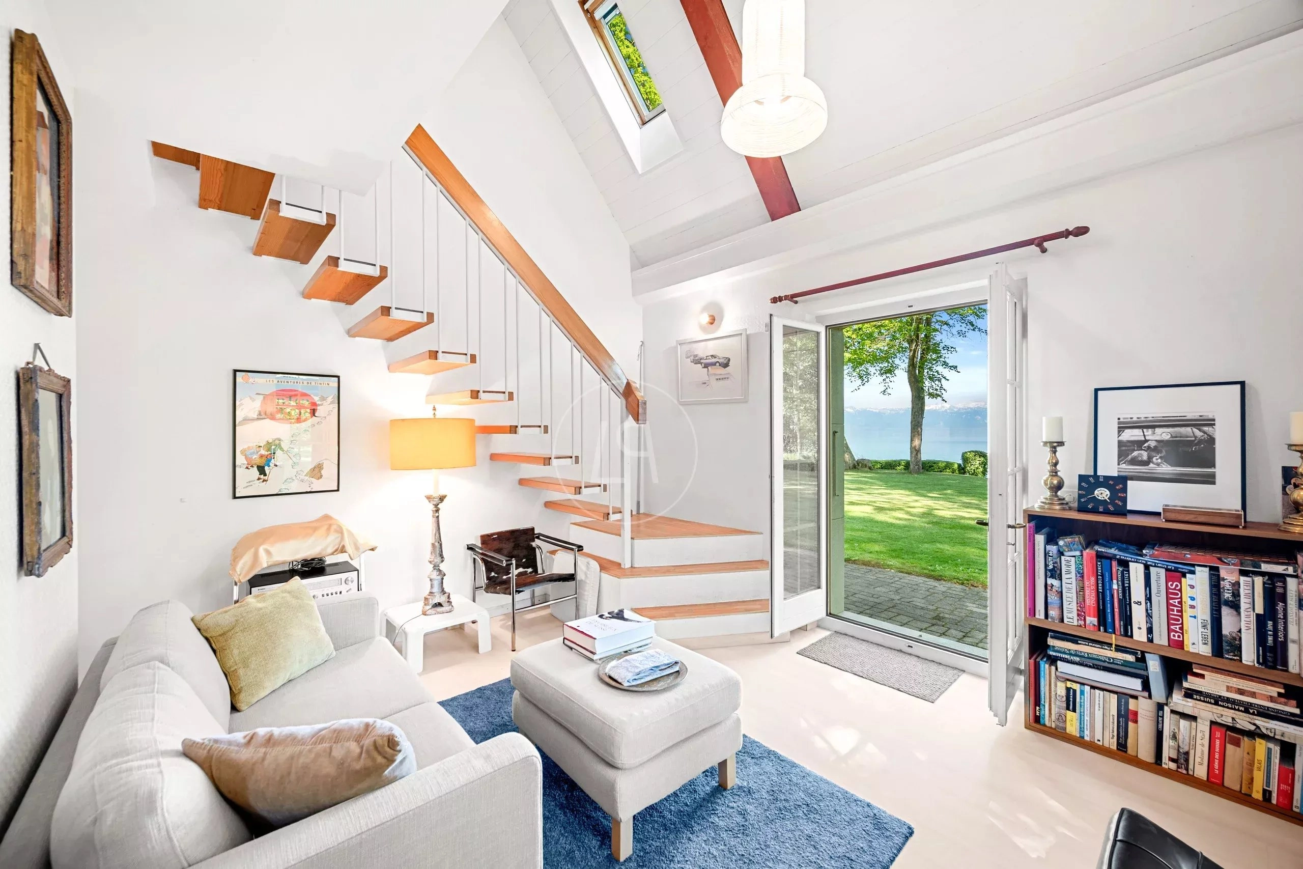 Heller Wohnbereich mit offener Treppe und Seeblick