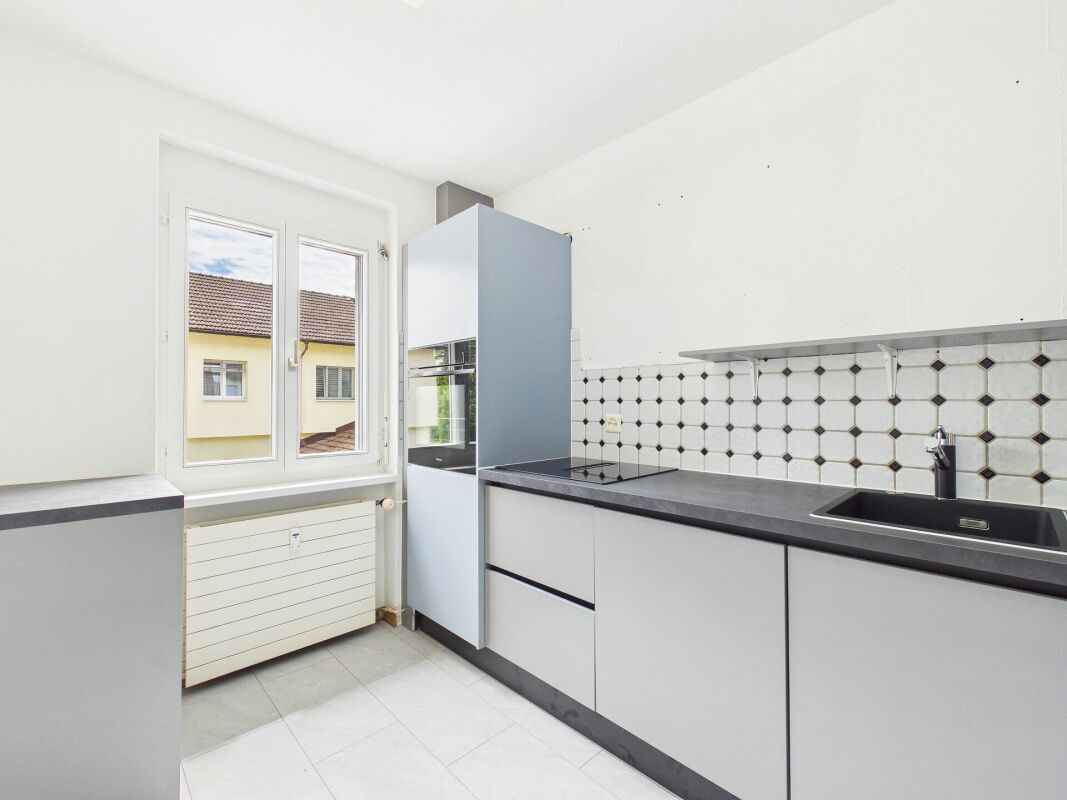 Helle moderne Küche mit Fenster und schlichten Fronten