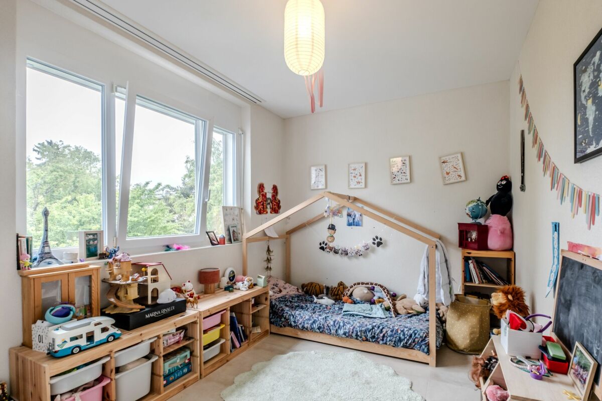 Kinderzimmer mit Hausbett und großen Fenstern