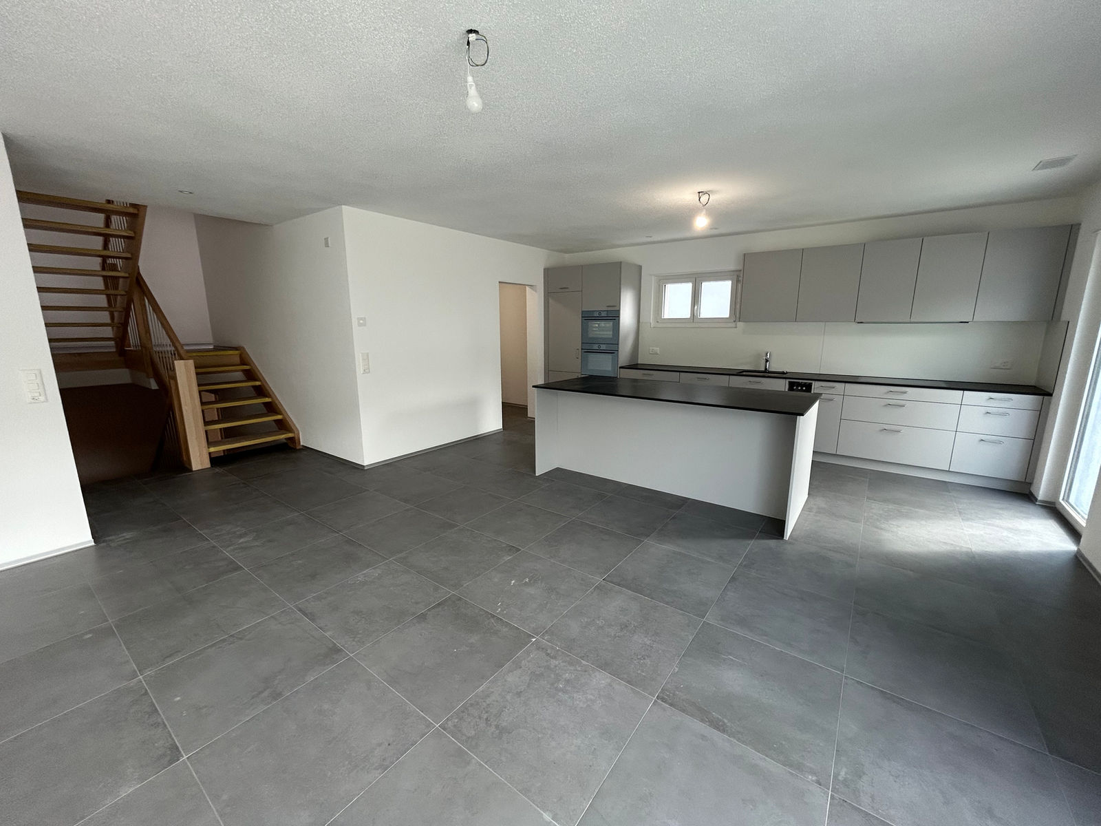 Offener Wohnbereich mit Küche und Treppe