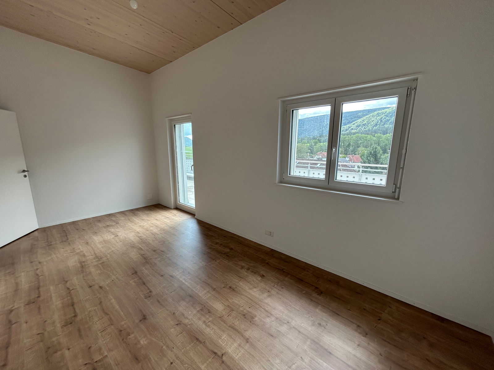 Leerer heller Raum mit Holzdecke und Ausblick ins Grüne