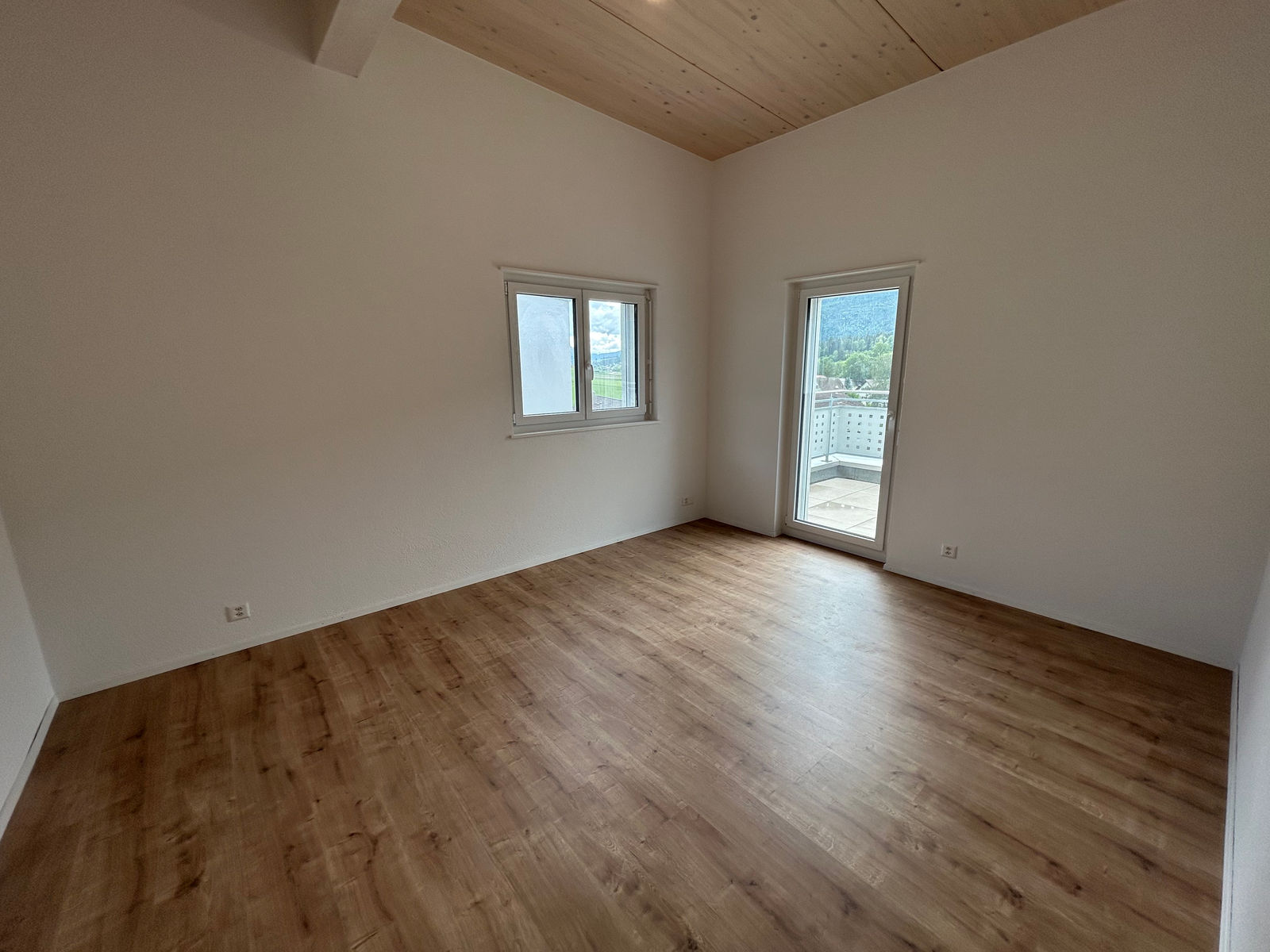 Leerer Raum mit Holzdecke und Balkonblick