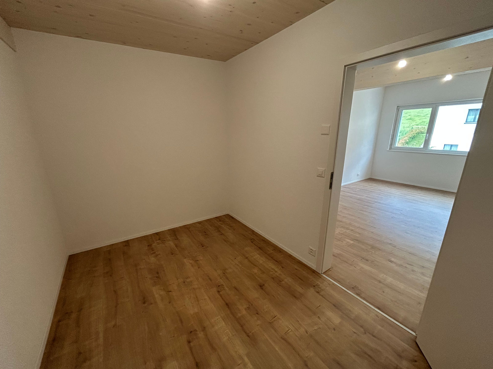 Leerer, modern renovierter Innenraum mit Holzoptikboden