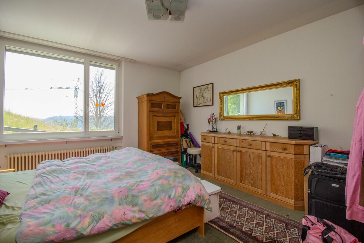 Schlafzimmer mit Holzmöbeln und großem Fenster