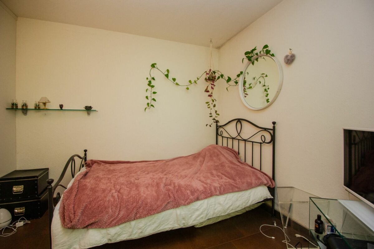 Kleines Schlafzimmer mit dunklem Metallbett