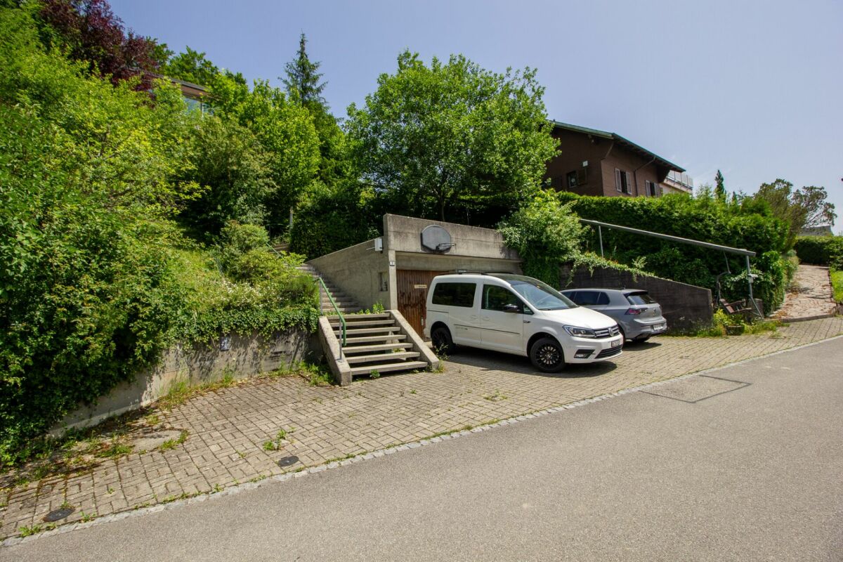 Außenansicht mit Zufahrt und Stellplätzen