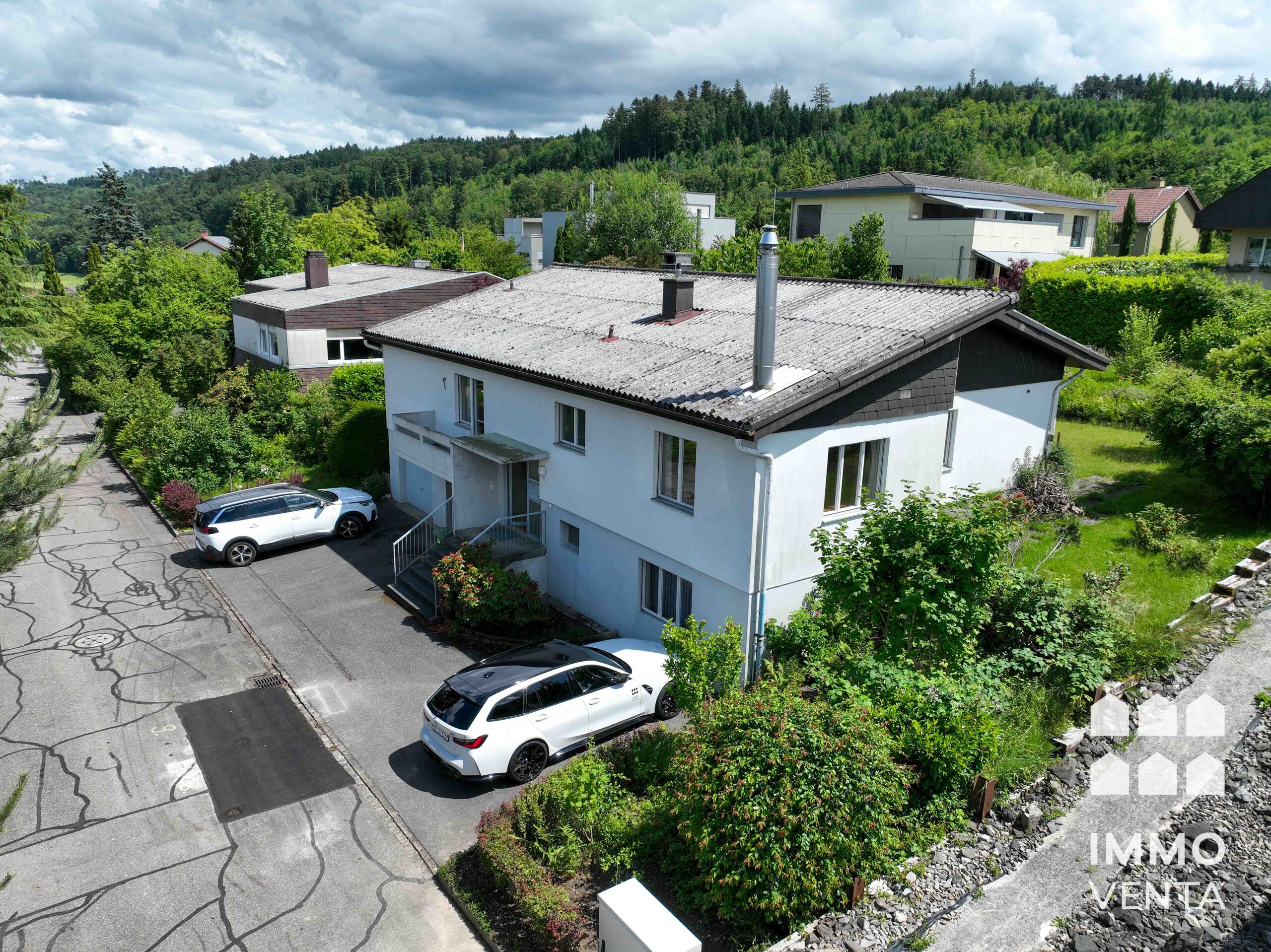 Luftaufnahme eines Wohnhauses in grüner Hanglage