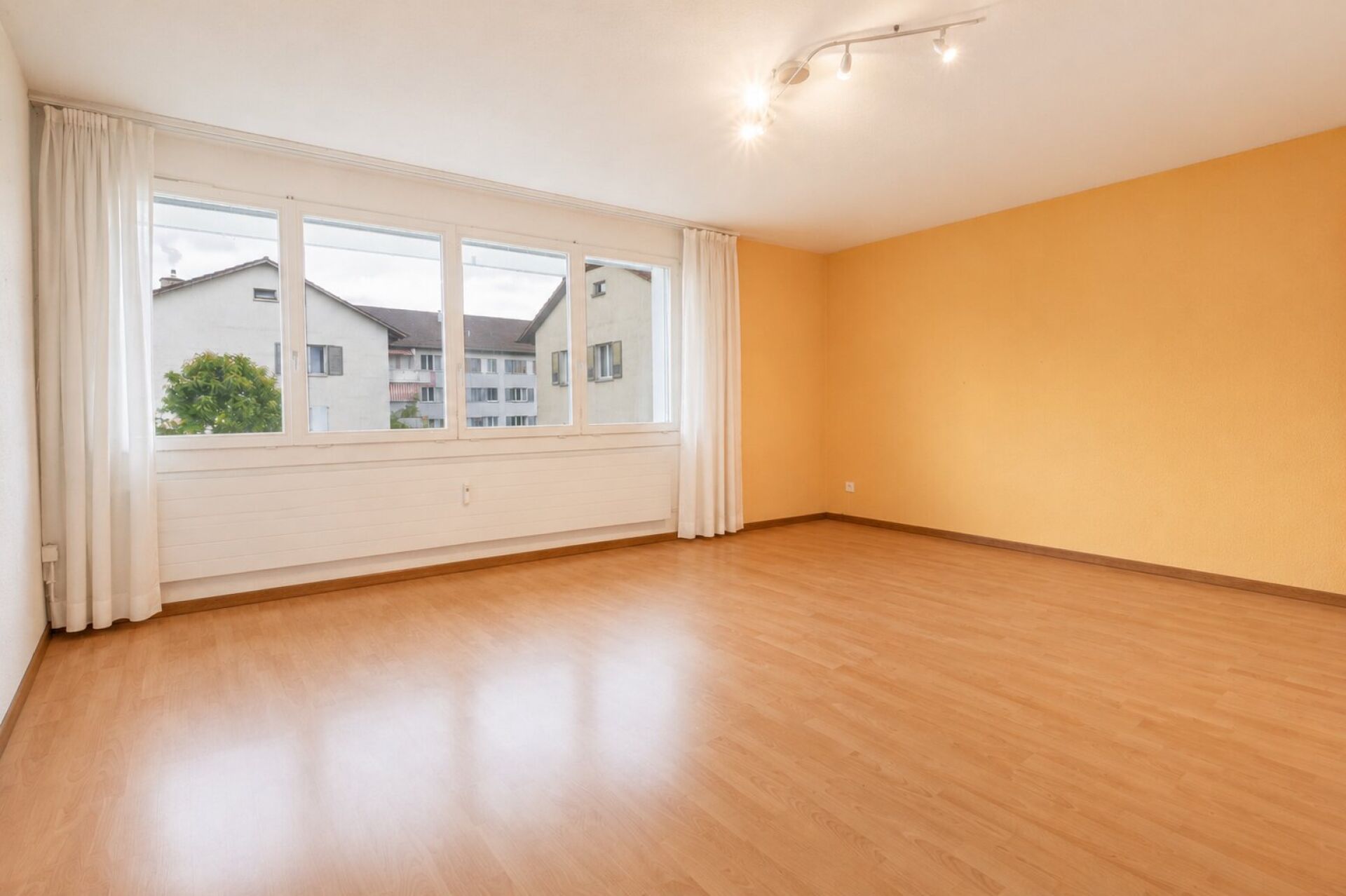 Heller leerer Wohnraum mit großer Fensterfront