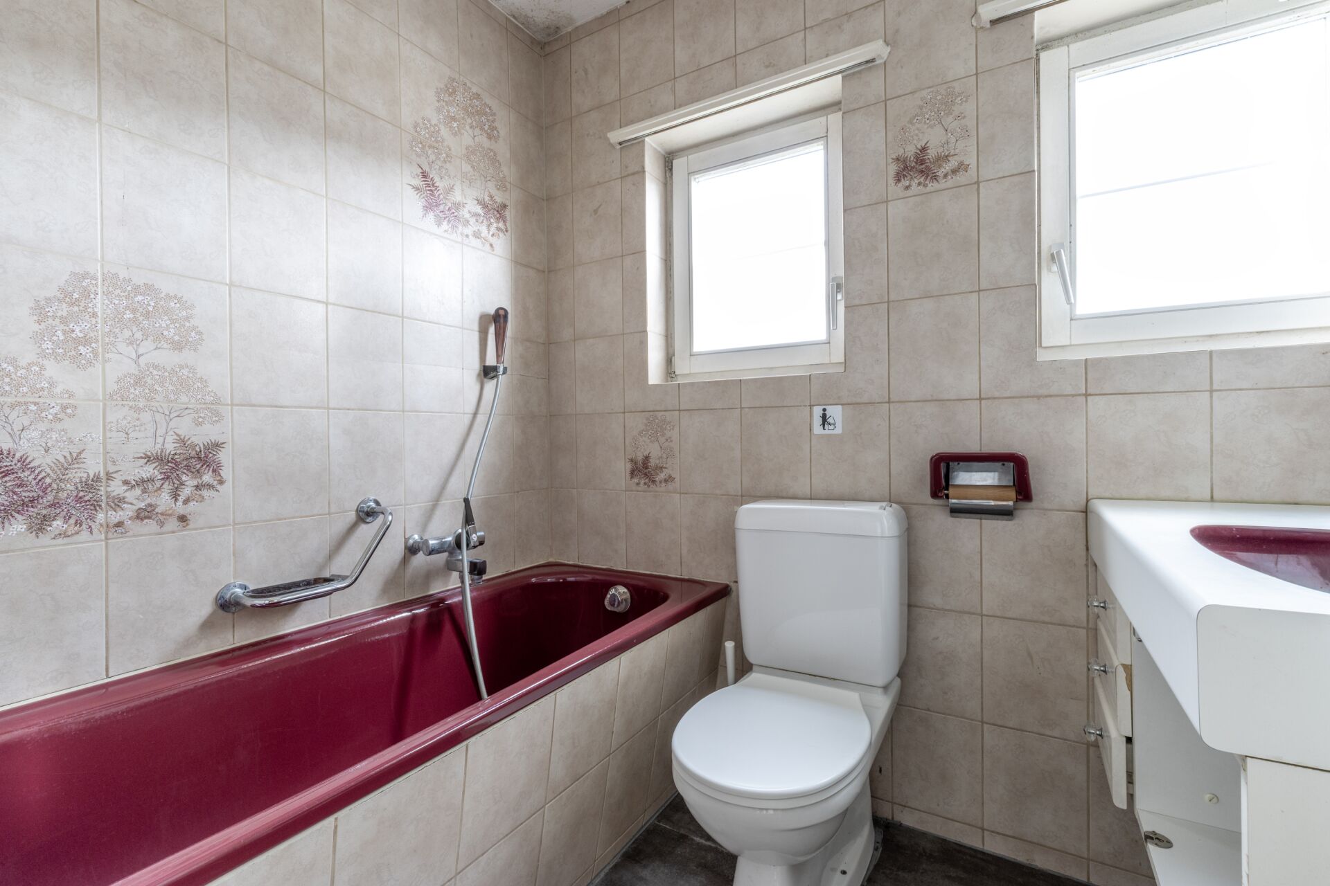 Kleines Badezimmer mit Badewanne, WC und Fenster