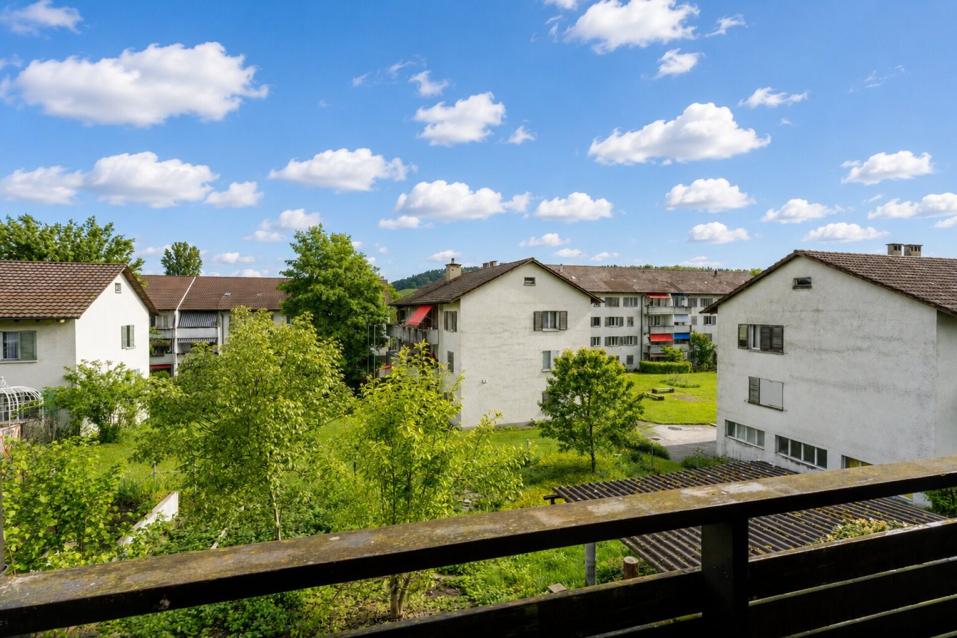 Blick vom Balkon auf Wohnanlage und Grünflächen