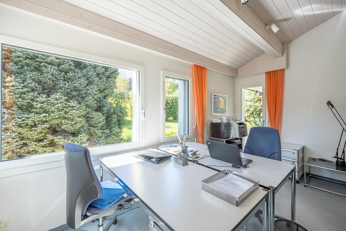 Helles Büro mit großen Fenstern und Schreibtisch