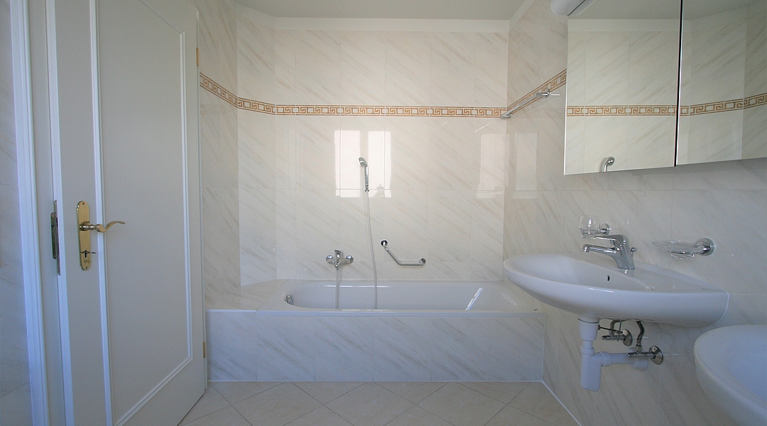 Helles Badezimmer mit Badewanne und Waschbecken