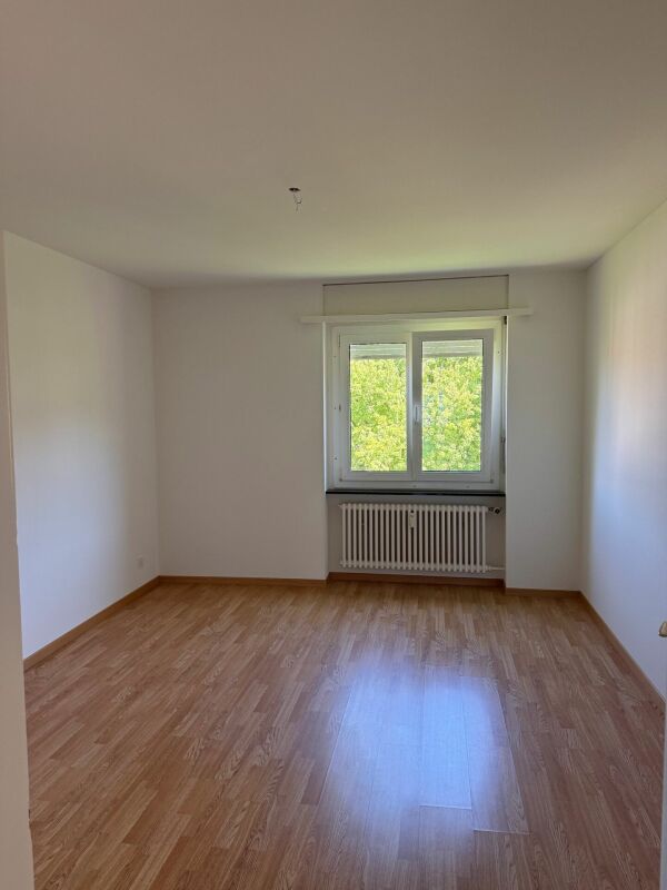 Leerer Wohnraum mit Fenster und Heizkörper