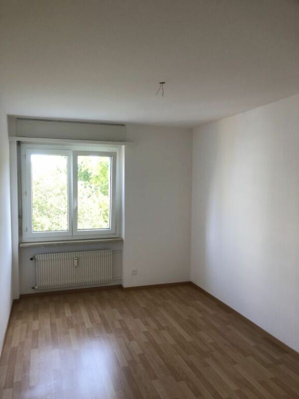 Leerer heller Raum mit Fenster und Heizkörper