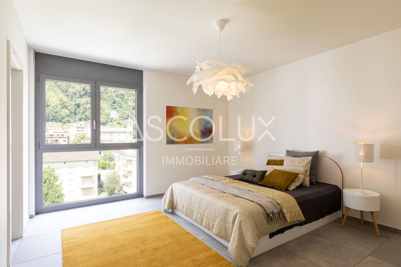 Helles Schlafzimmer mit großem Fenster und Stadtblick