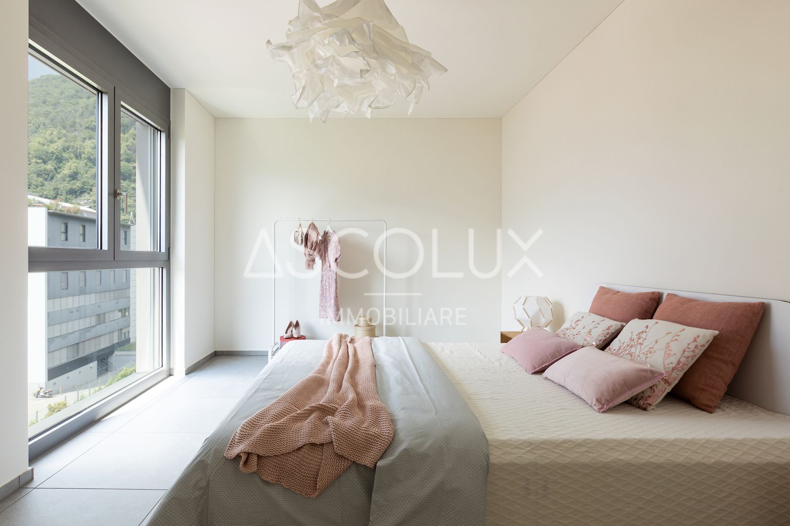 Helles Schlafzimmer mit großem Fenster und minimalistischer Einrichtung