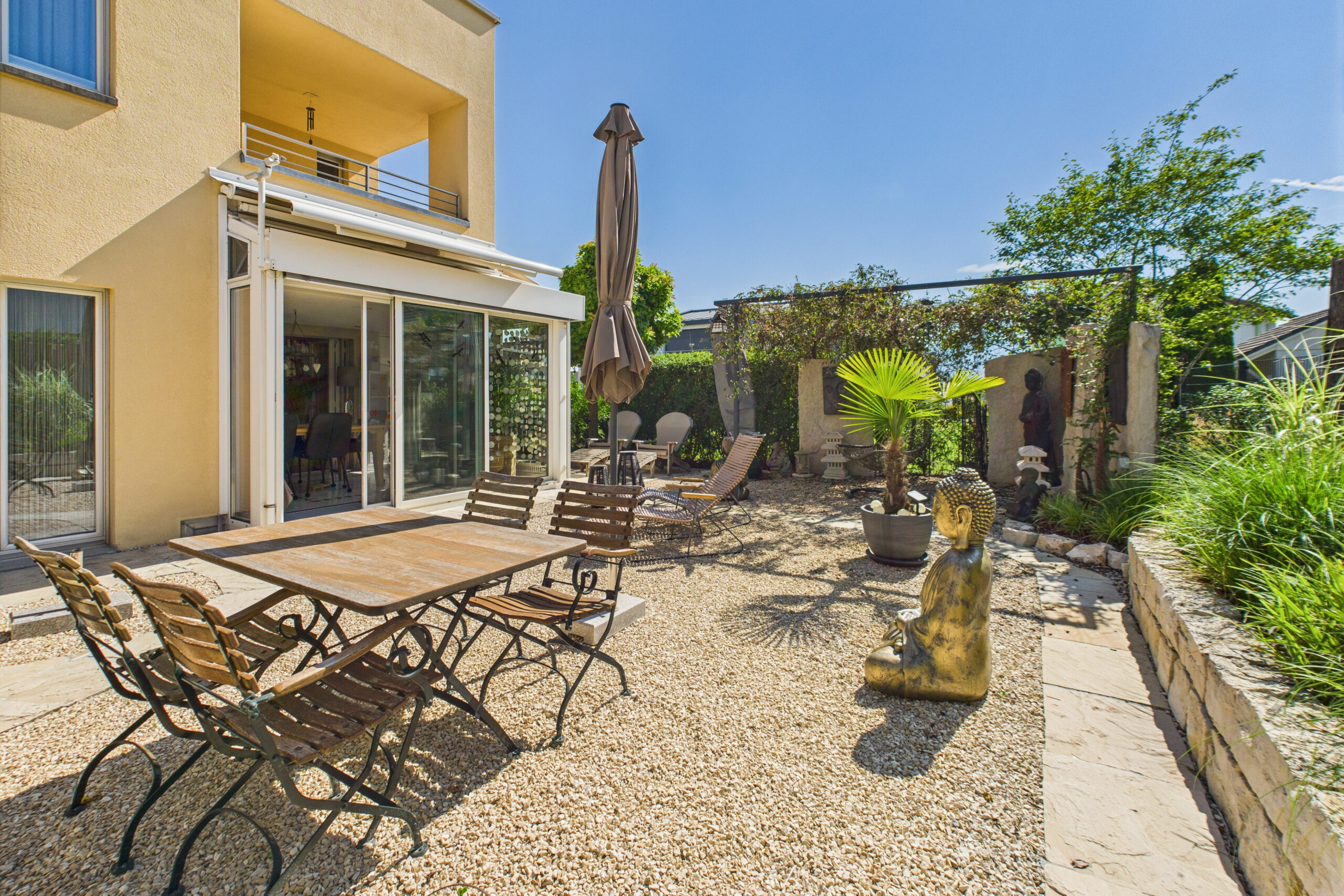 Sonnige Terrasse mit Gartenmöbeln