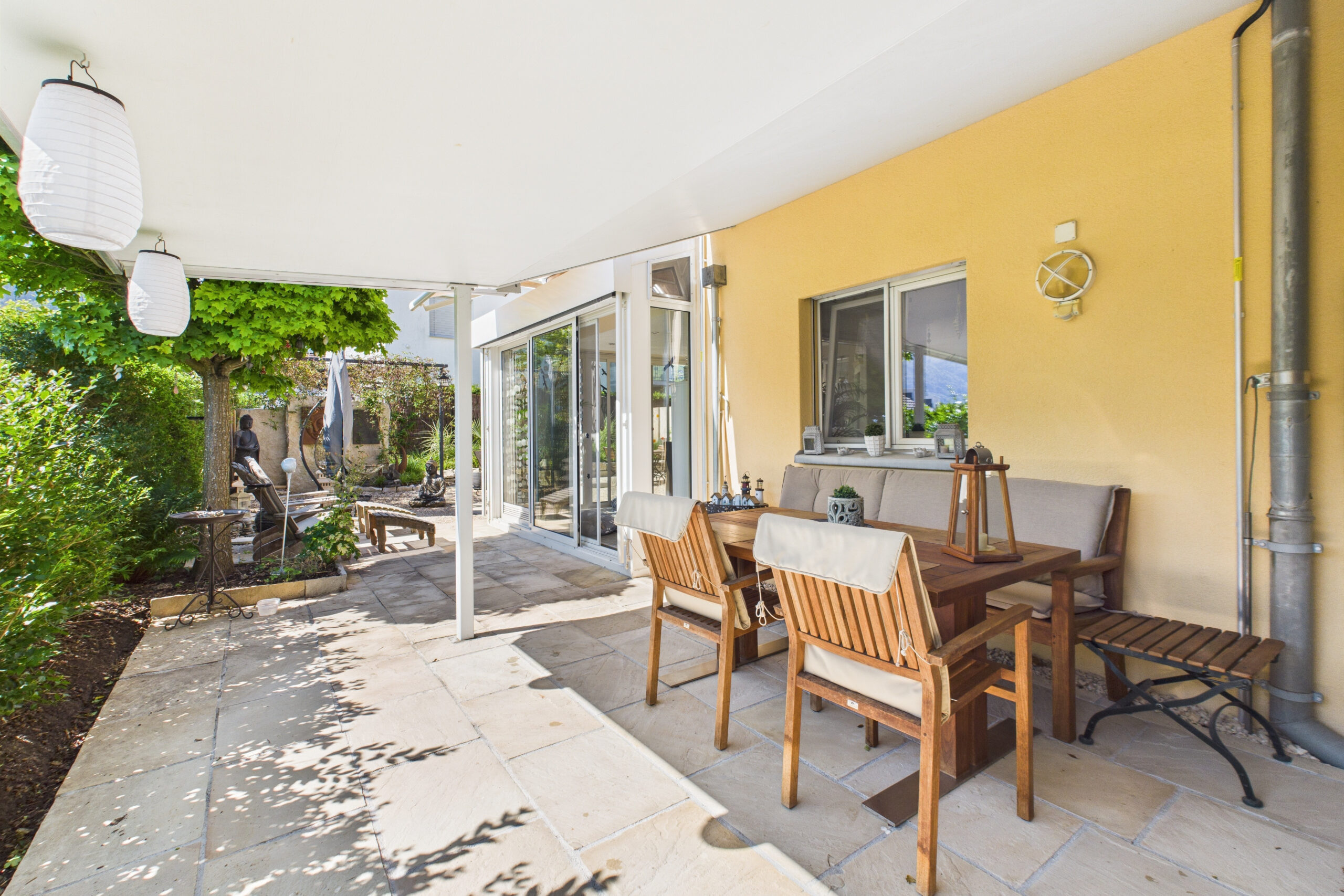 Überdachte Terrasse mit Gartenblick