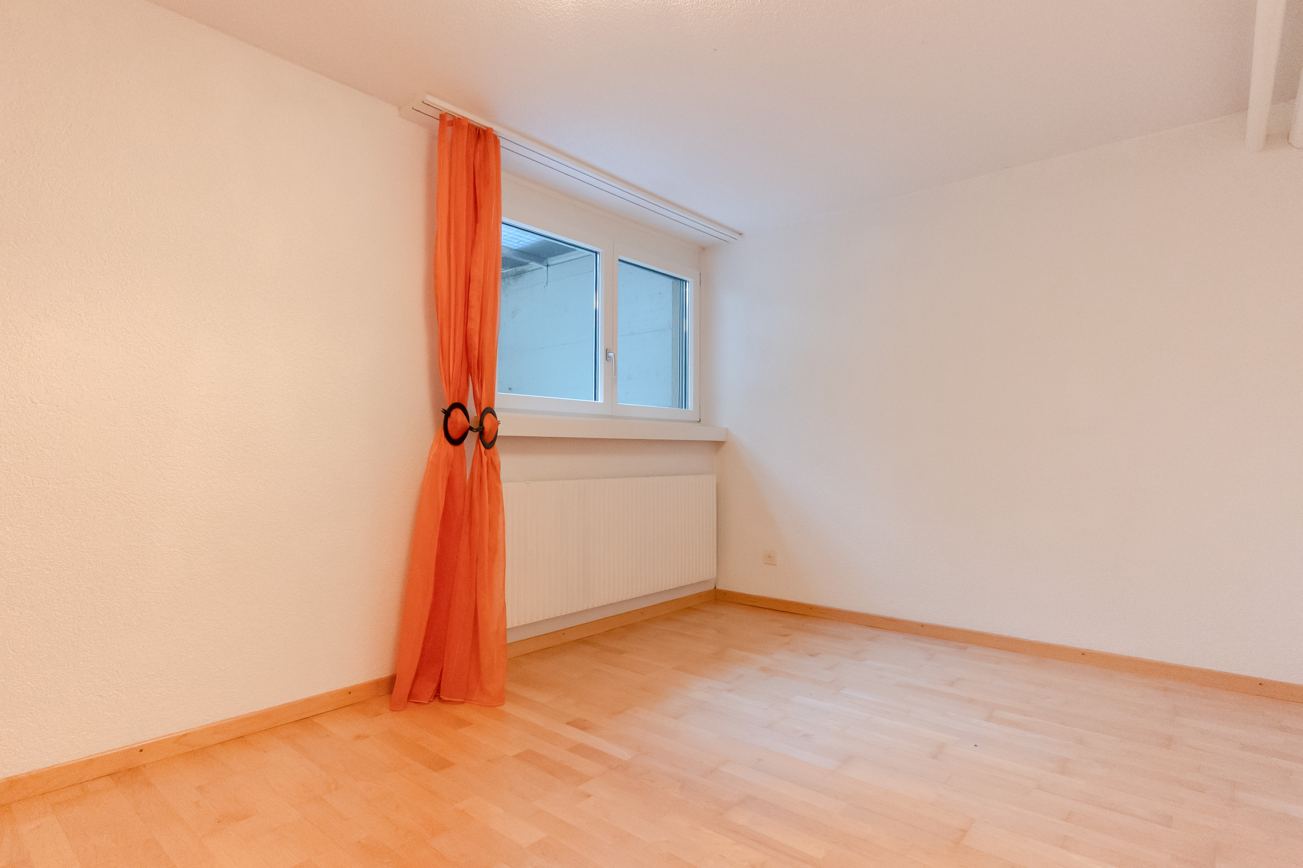 Leeres Zimmer mit Fenster und Heizkörper