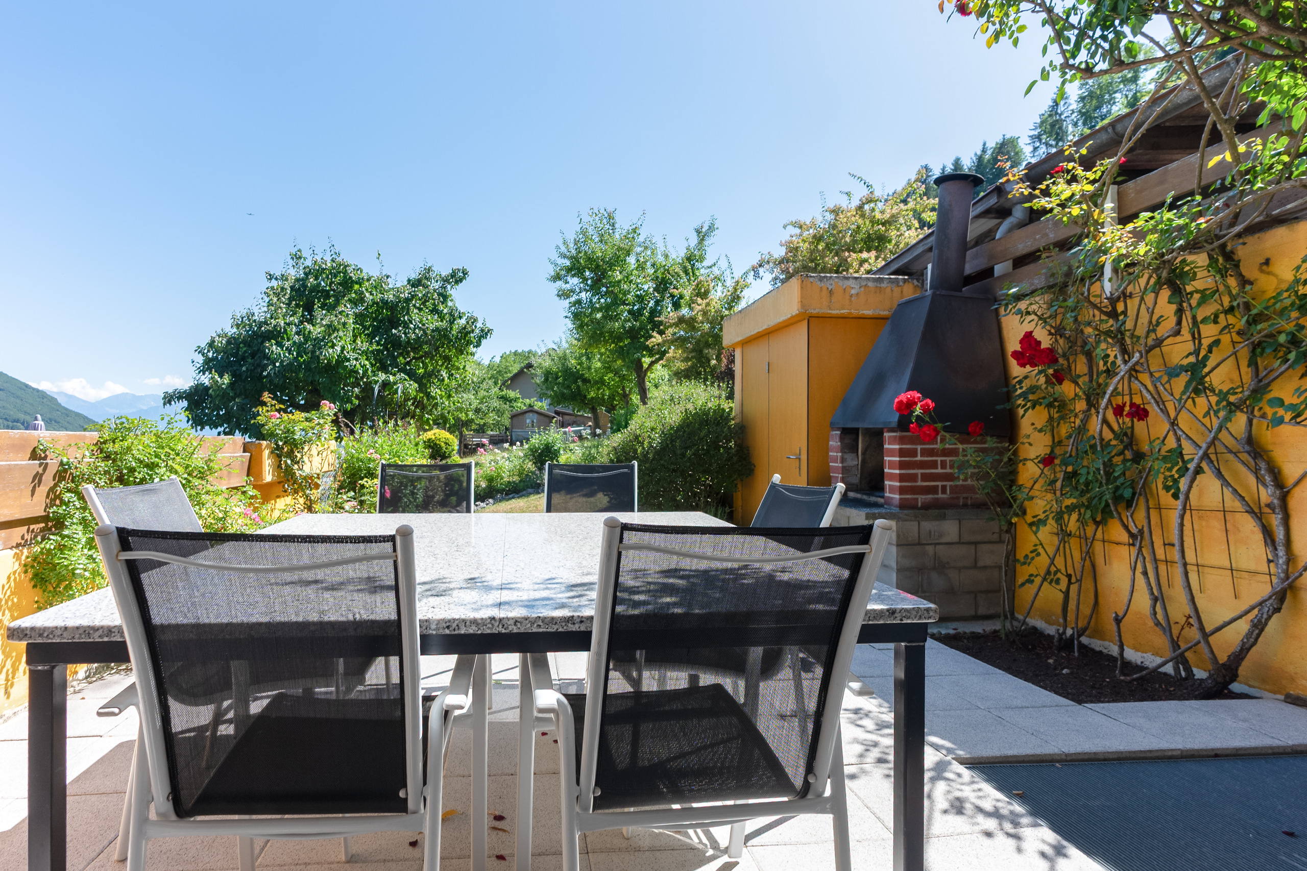 Terrasse mit Esstisch und Grillbereich