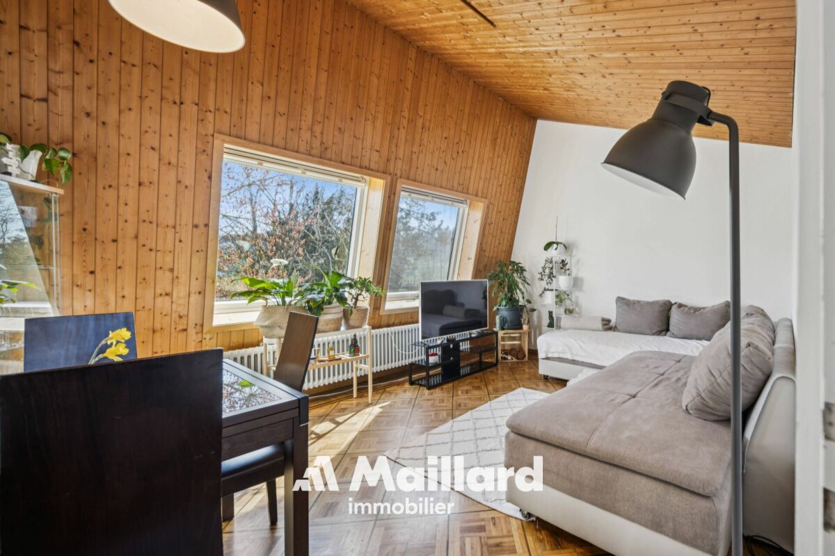 Wohnzimmer mit Holzverkleidung und Dachschräge