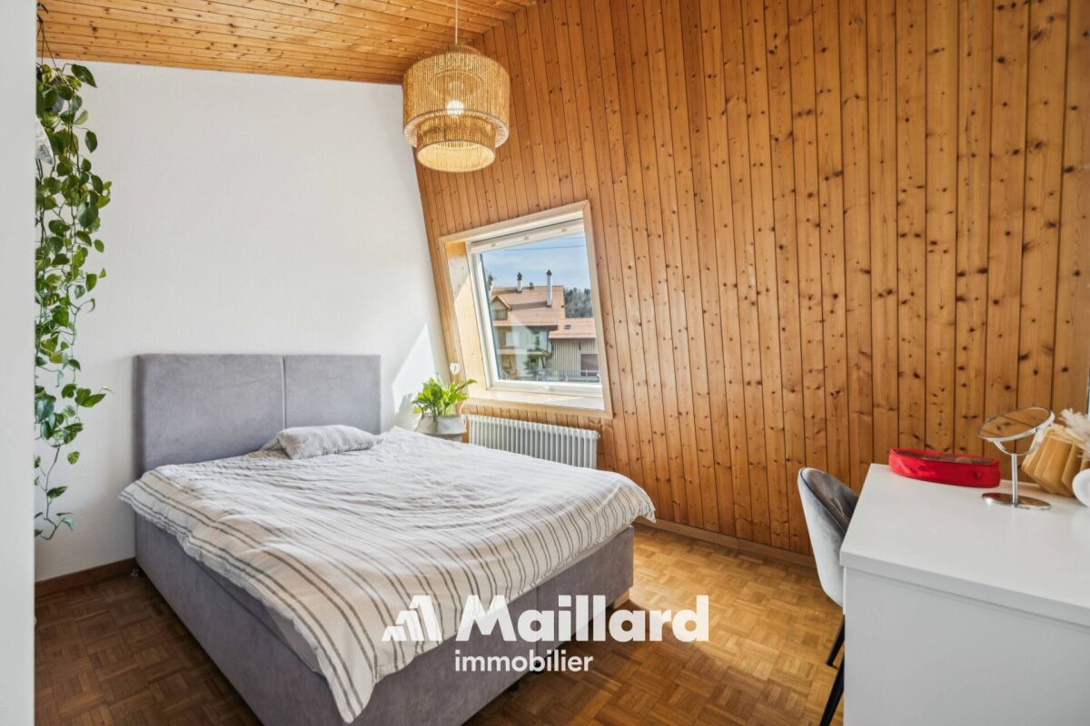 Gemütliches Schlafzimmer mit Holzdecke und Holzvertäfelung