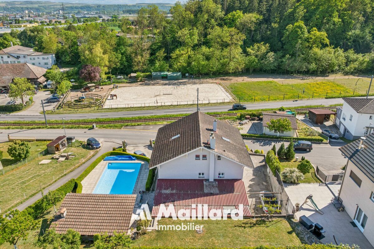 Luftaufnahme eines Einfamilienhauses mit Pool und Garten