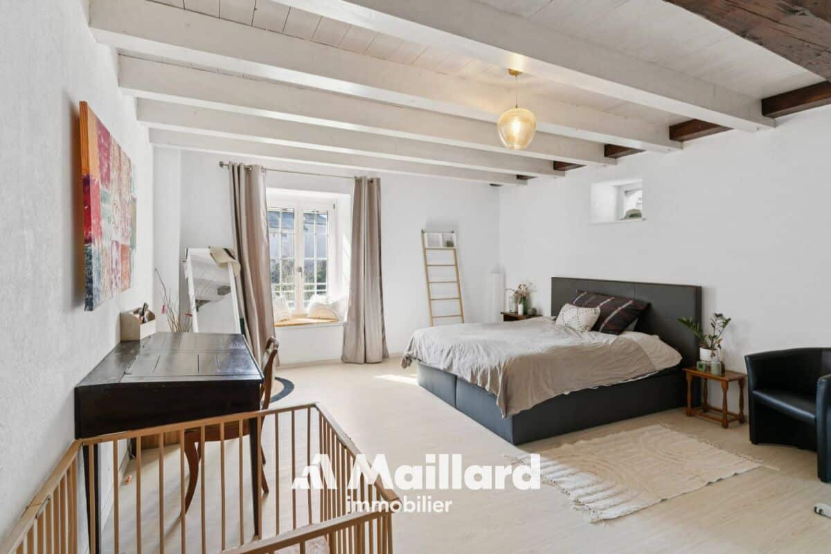Helles Schlafzimmer mit sichtbaren Holzbalken und Dachschräge