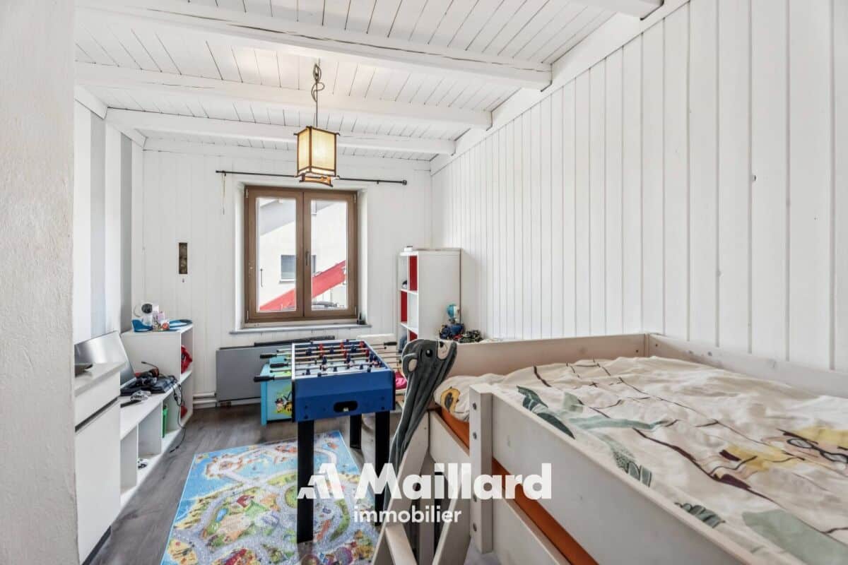 Kinderzimmer mit Spieltisch und Bett