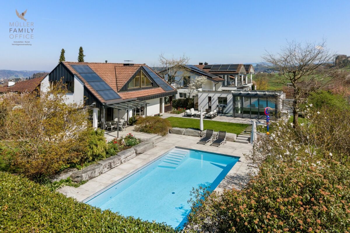Außenansicht eines Wohnhauses mit Pool und Garten