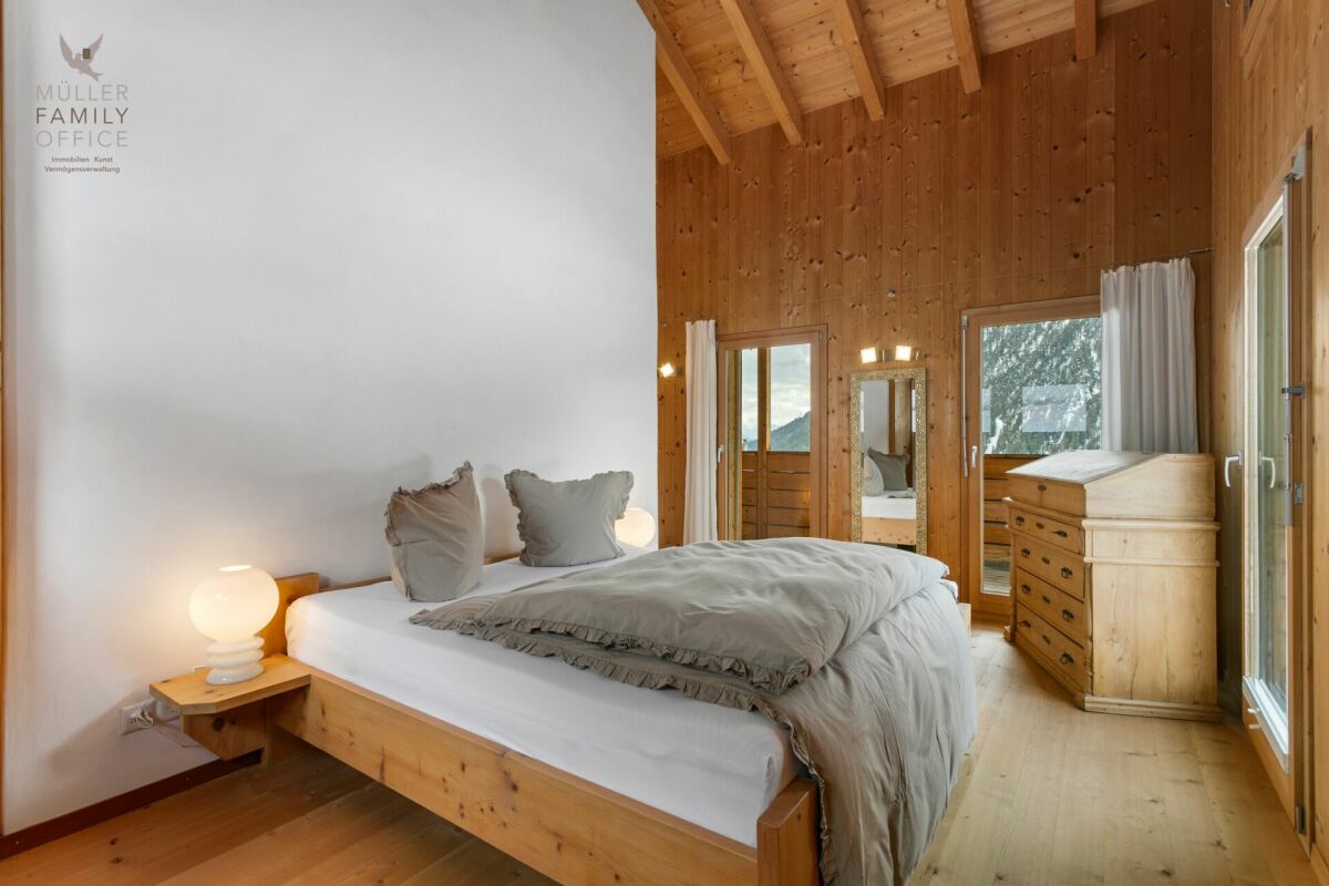 Rustikales Schlafzimmer mit Holzvertäfelung und Bergblick