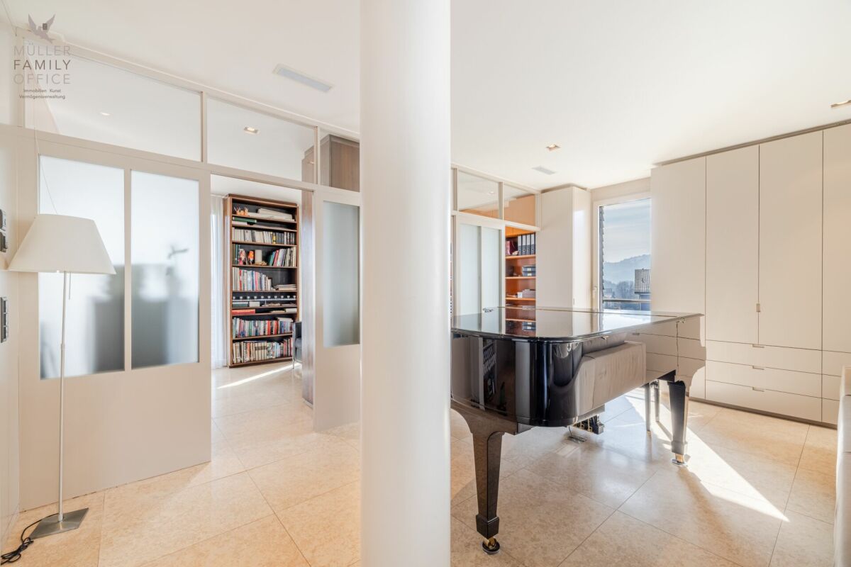 Helles Musikzimmer mit Flügel und Bibliothek