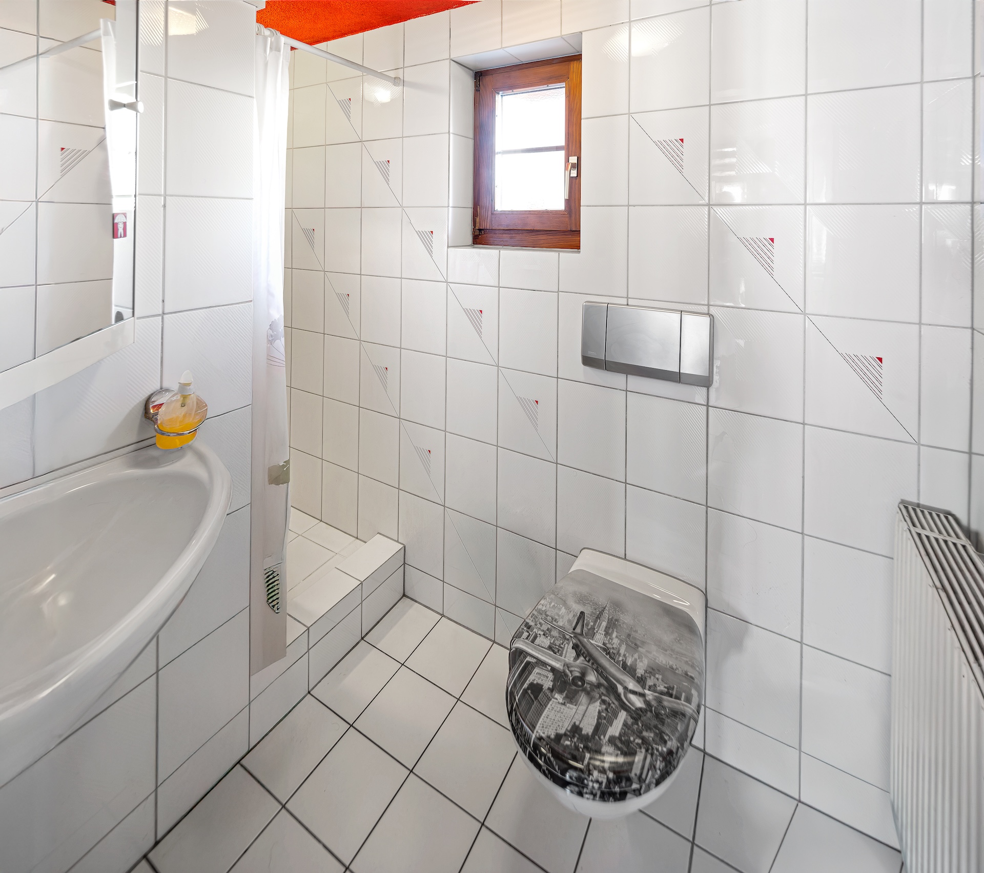 Kleines gefliestes Badezimmer mit WC und Fenster