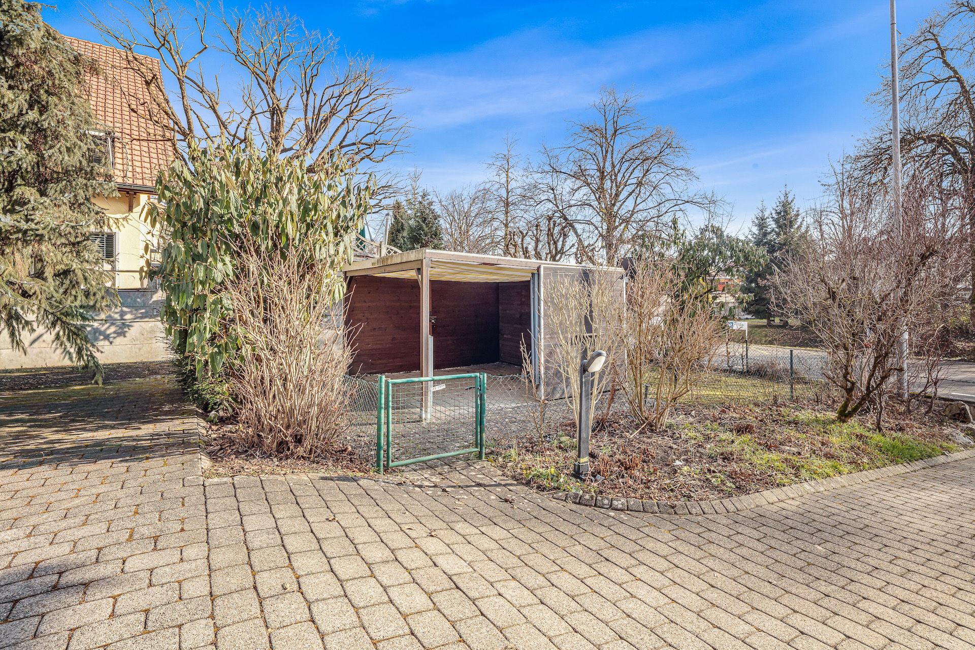 Außenansicht eines Grundstücks mit Zufahrt und Gartenbereich