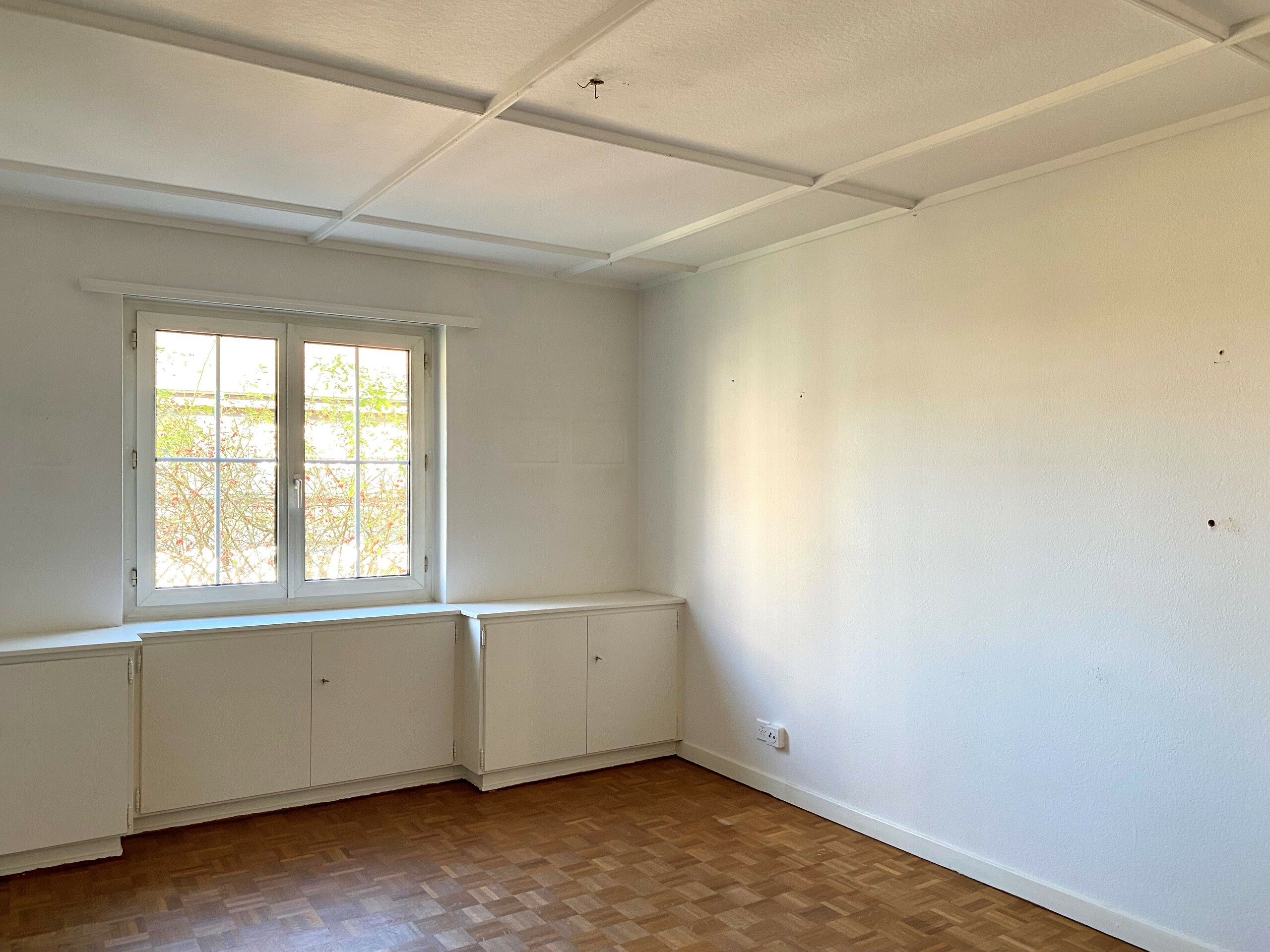 Leerer heller Raum mit Fenster und Einbauschränken