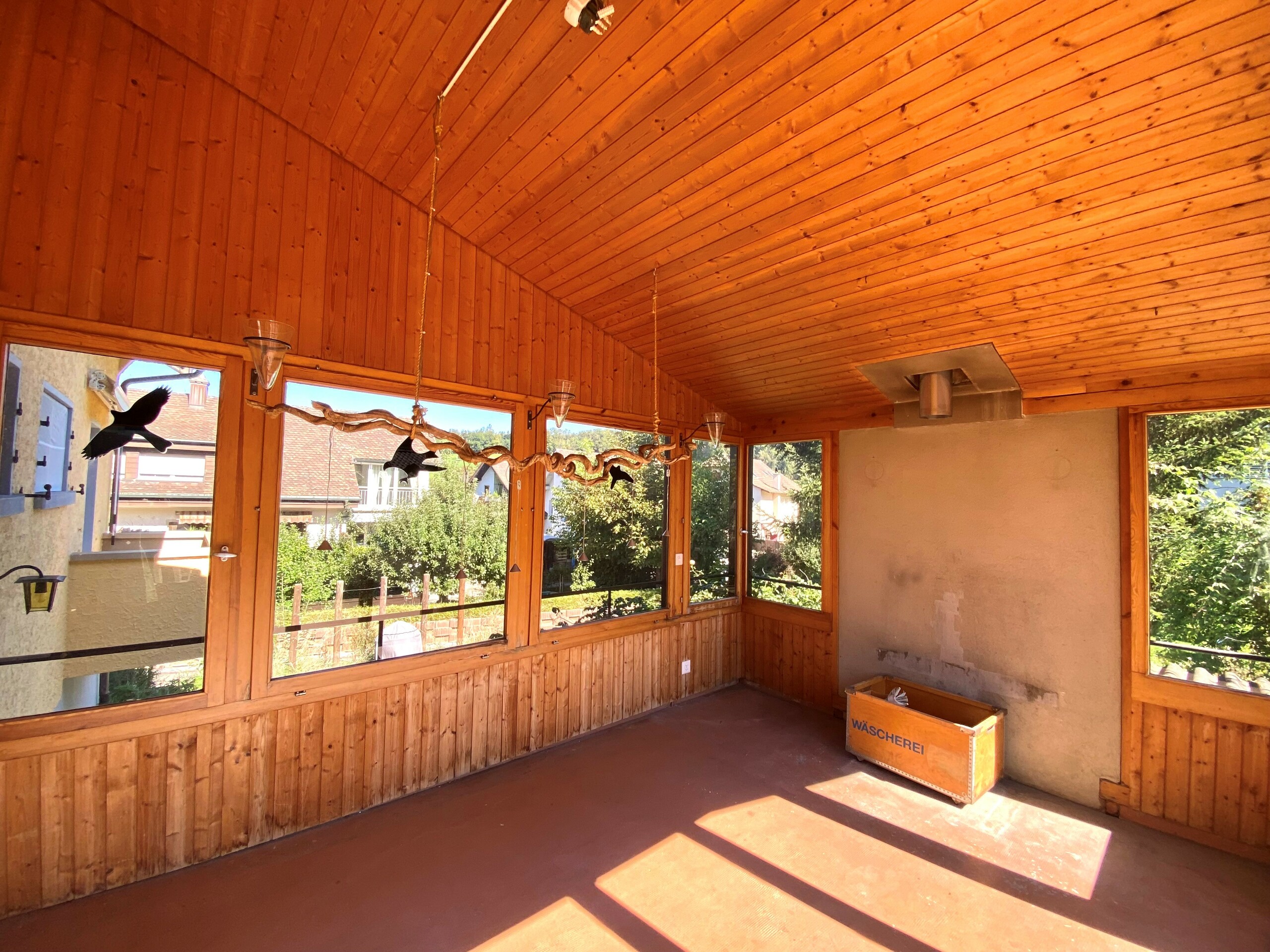 Verglaster Holzraum mit Sonnenlicht