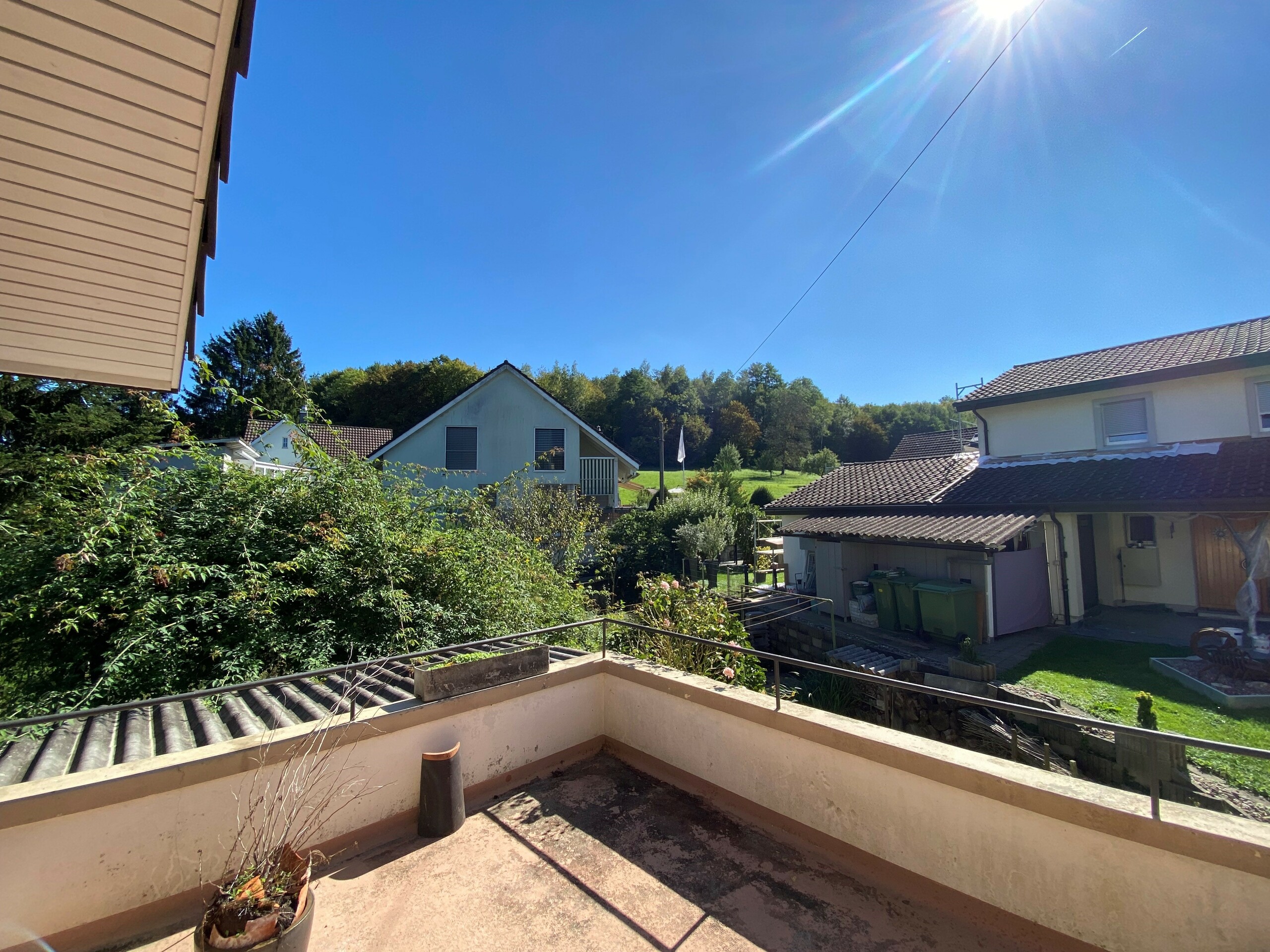 Balkon mit Blick auf Nachbarhäuser und Grünfläche
