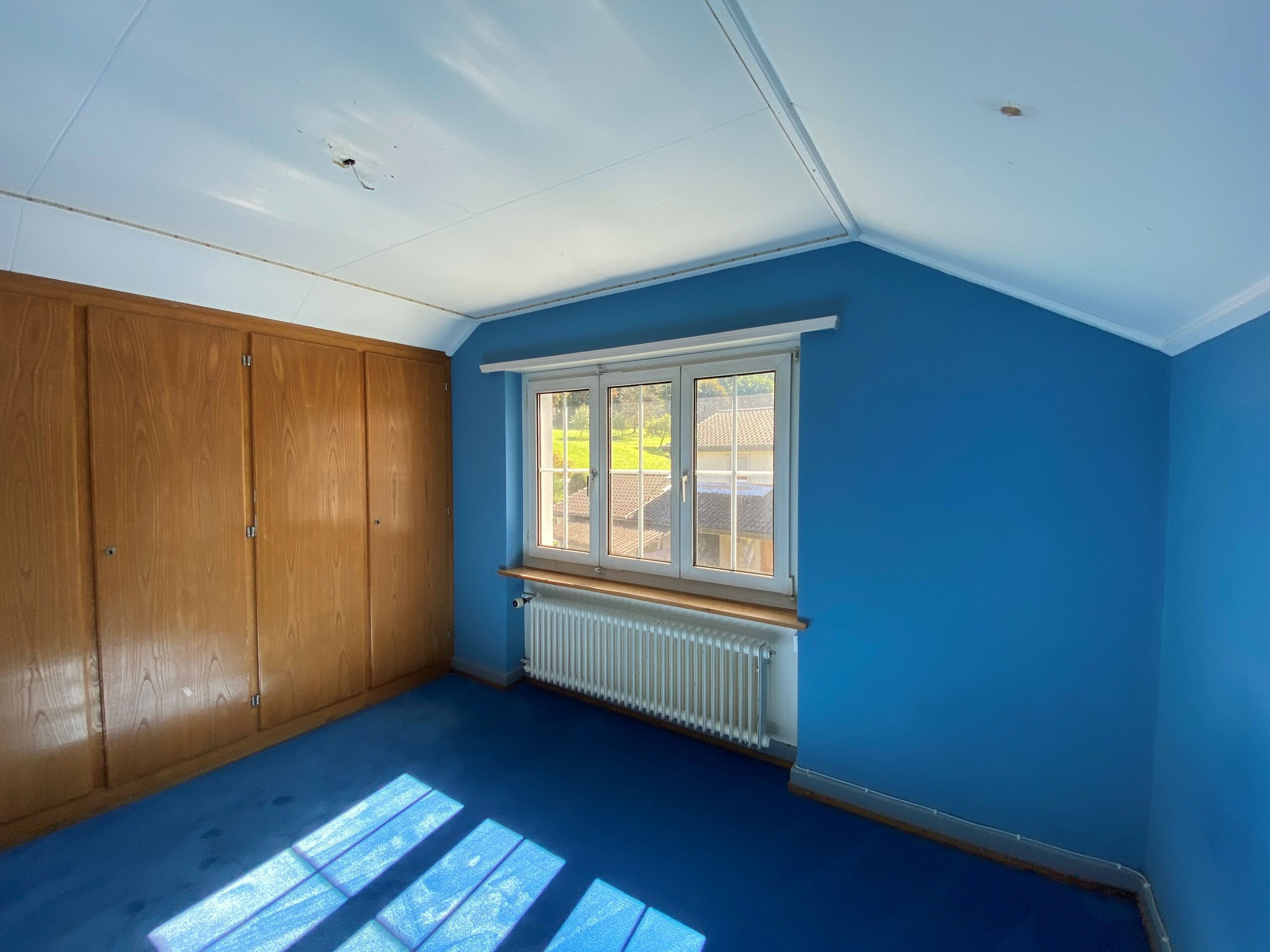 Blau gestrichenes Schlafzimmer mit Einbauschrank