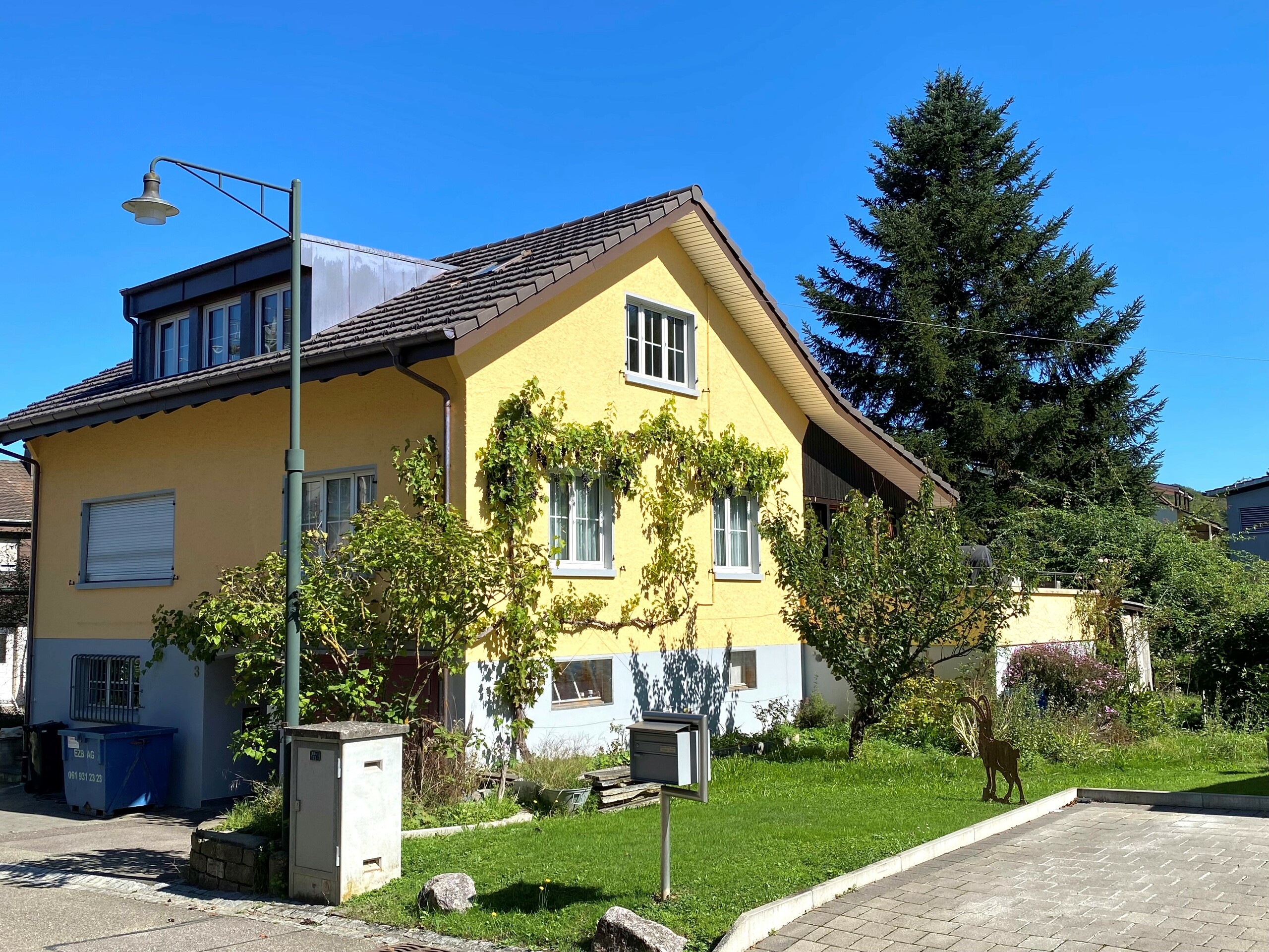 Gelbes Einfamilienhaus mit Satteldach und gepflegtem Garten