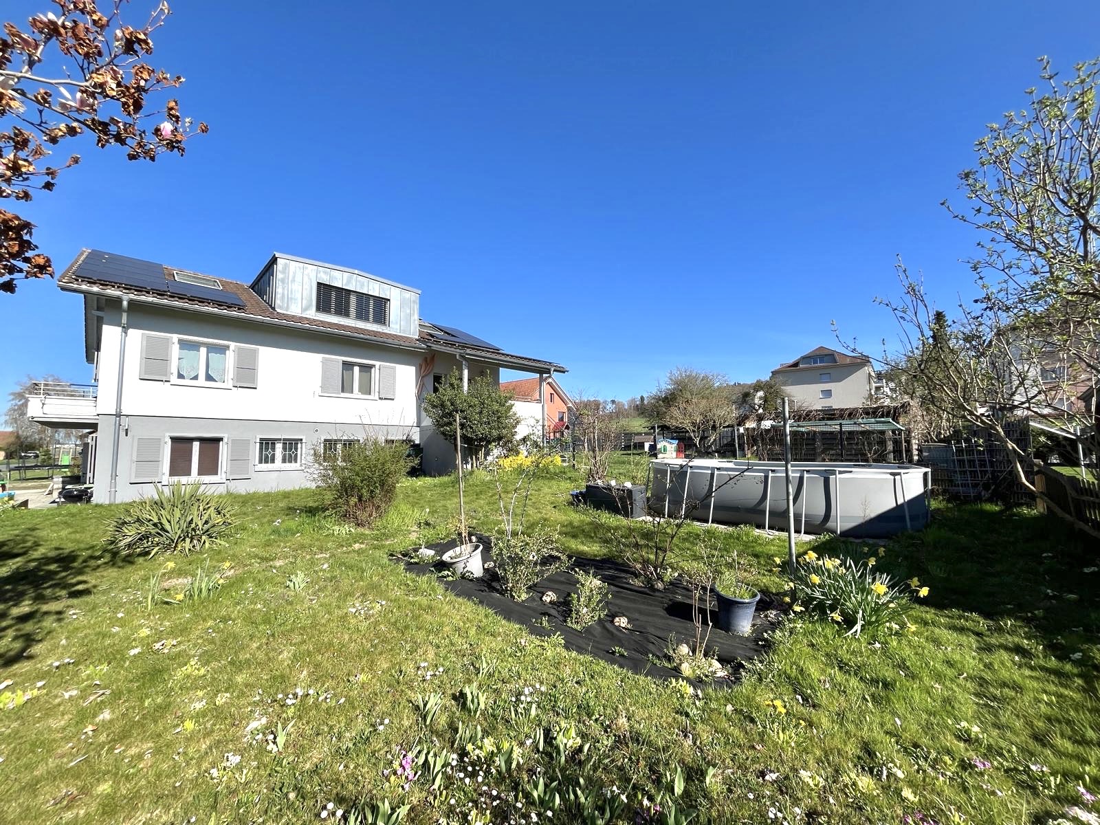 Außenansicht eines Wohnhauses mit Garten und Pool