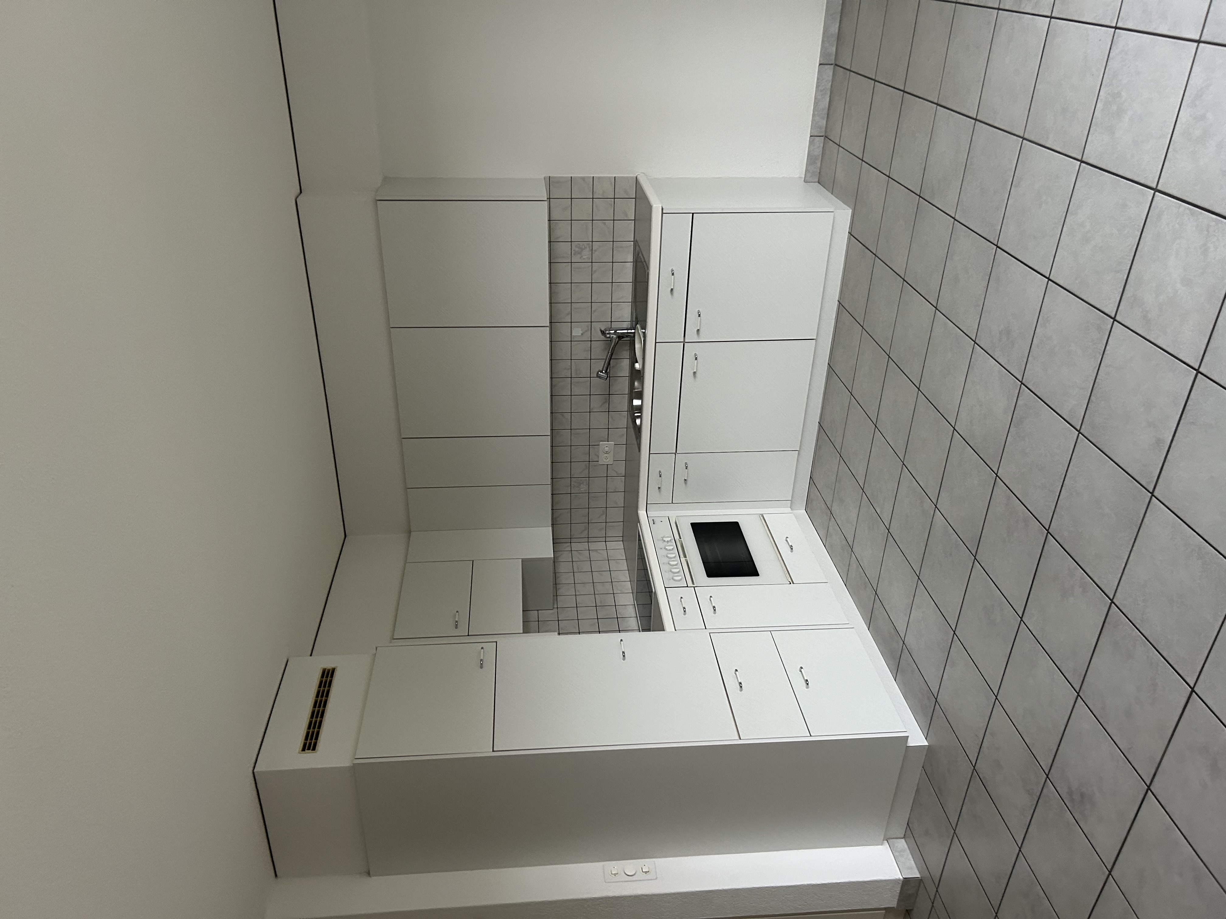 Kleine helle Küche mit weißen Einbaumöbeln