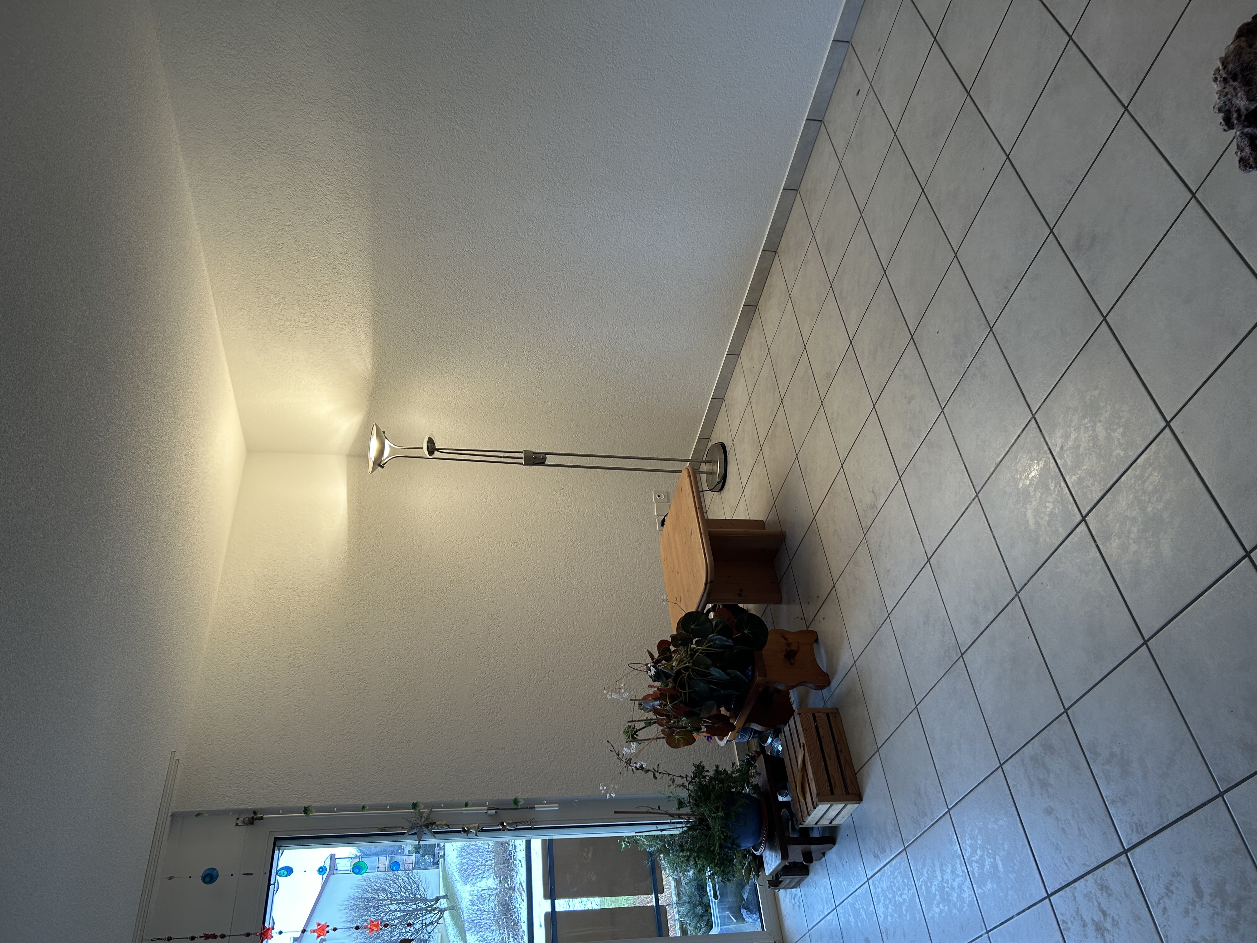 Heller leerer Wohnraum mit Fenster und Stehlampe