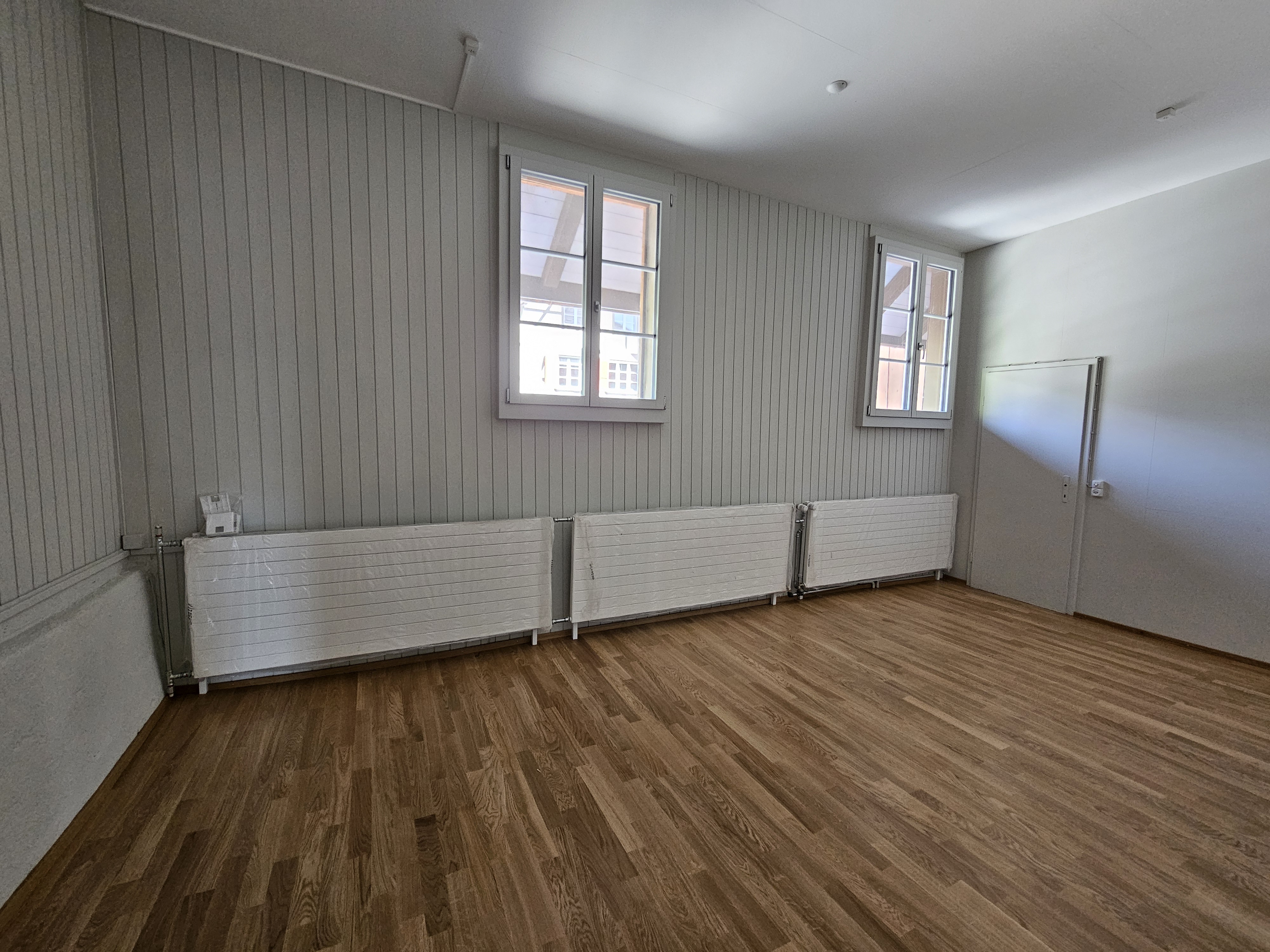 Leerer heller Raum mit Holzfußboden