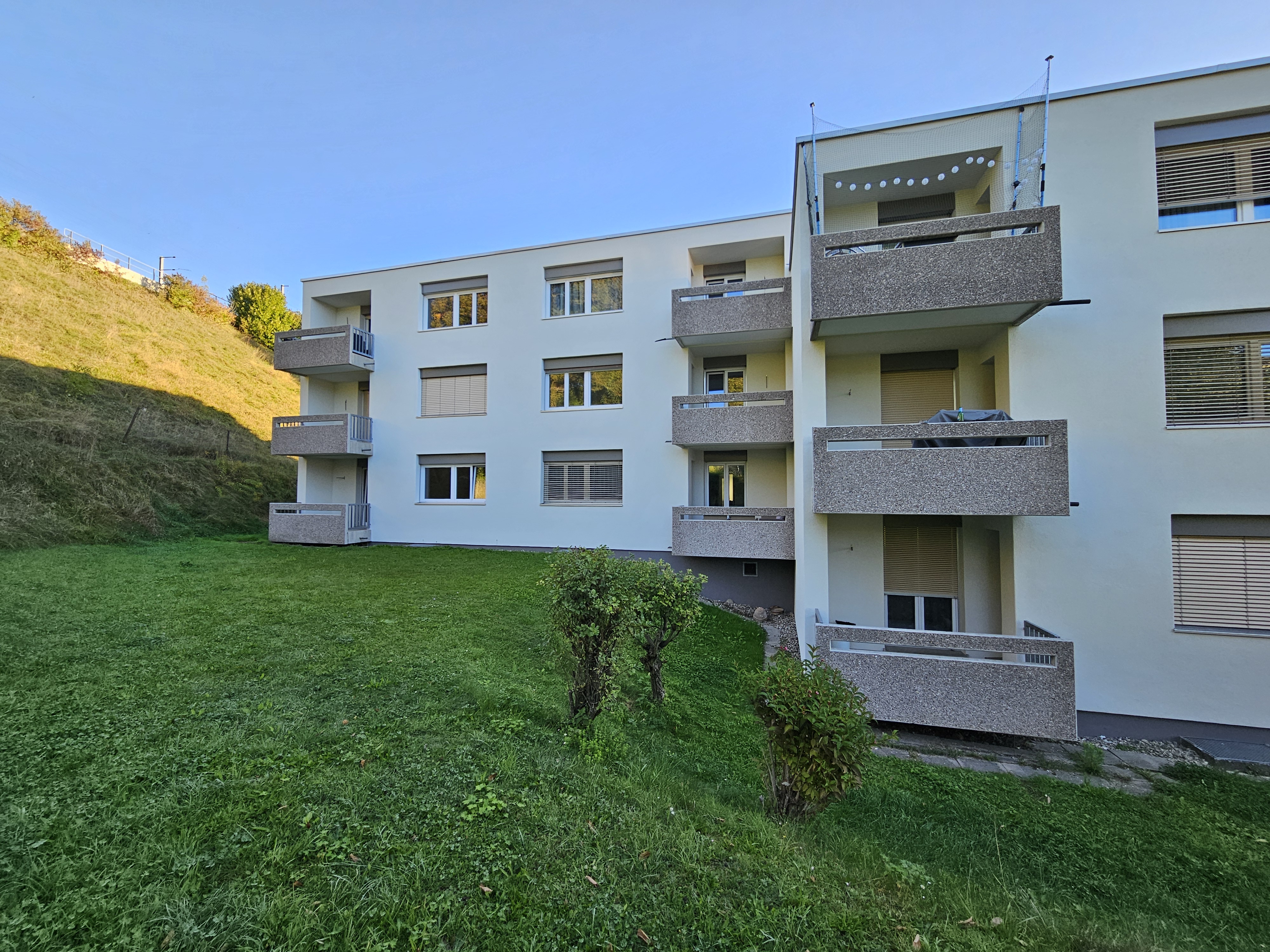 Modernes Mehrfamilienhaus mit Balkonen und Grünfläche