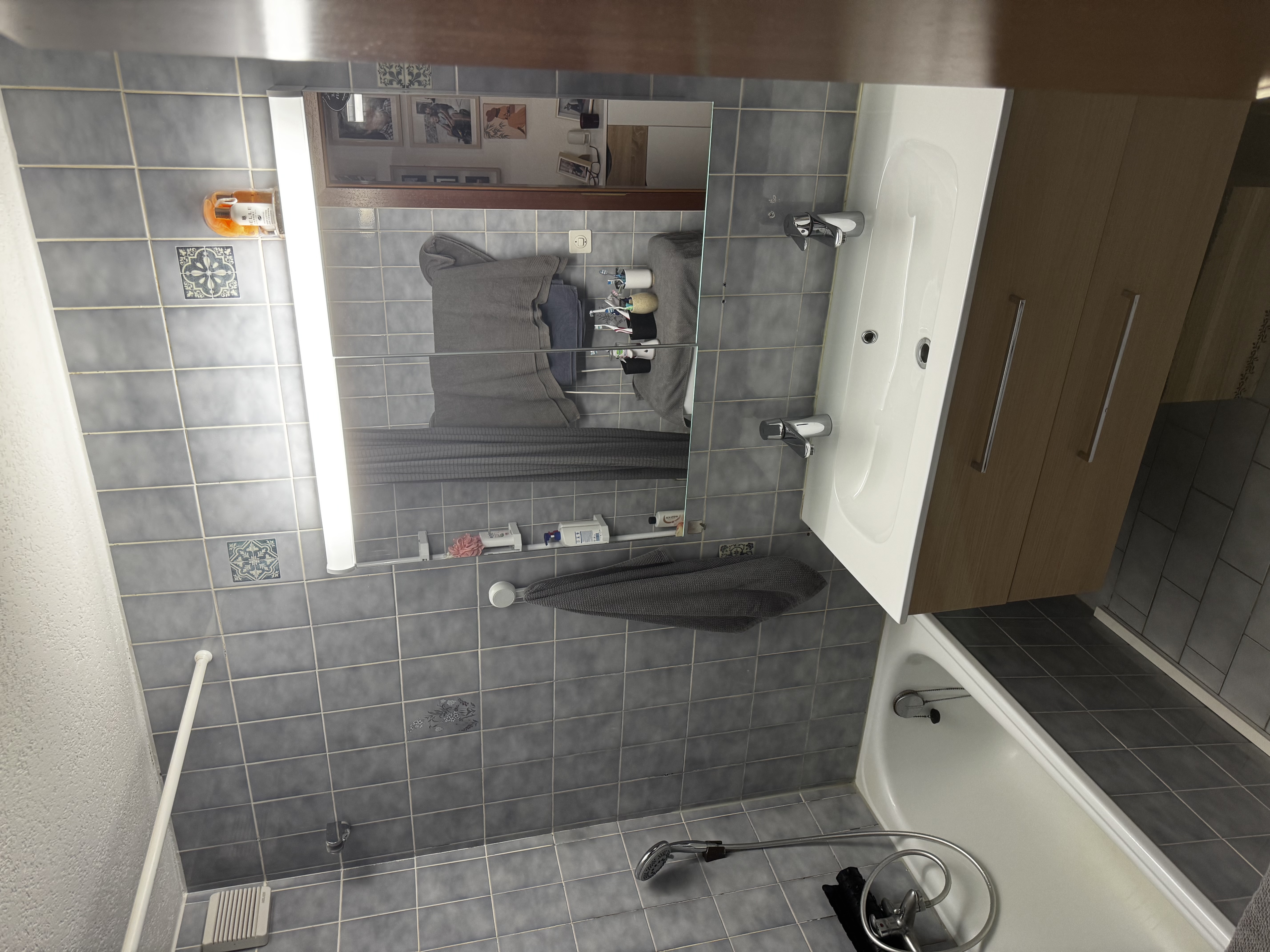 Kleines Badezimmer mit Badewanne und Waschtisch