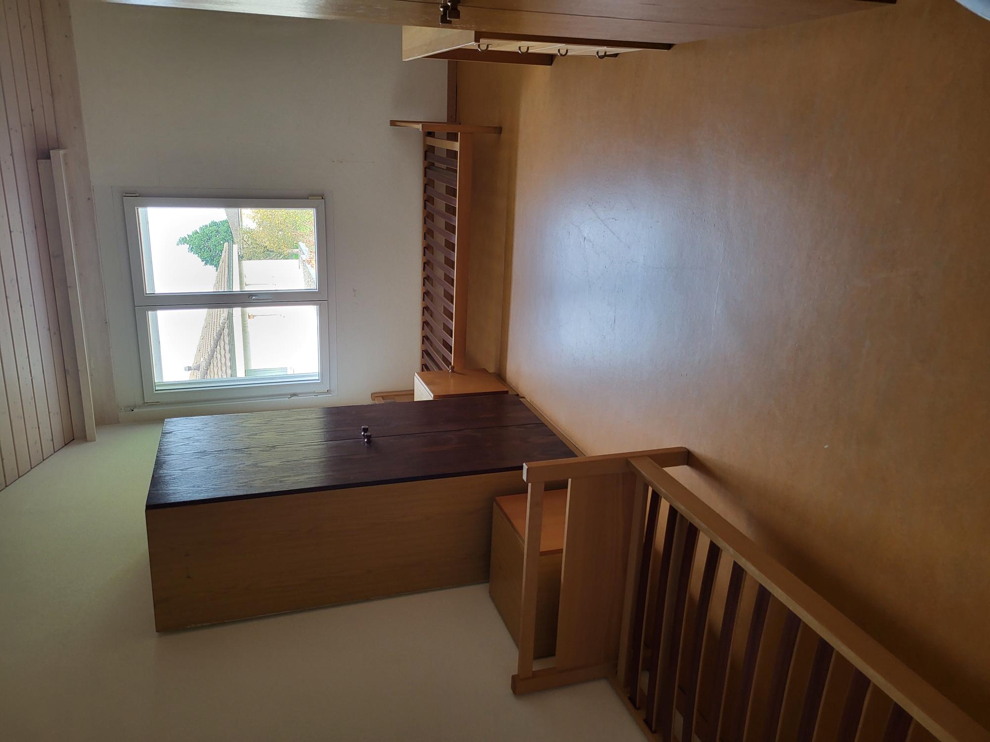 Ein schlichtes Schlafzimmer mit zwei Einzelbetten und Garderobenschrank
